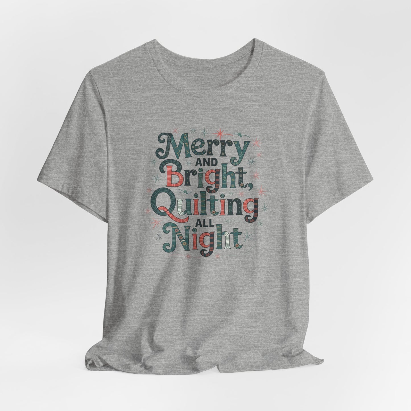 An Athletic Heather christmas quilting T-shirt featuring a whimsical design with the phrase "Merry and Bright, Quilting All Night," featuring festive quilting patterns and holiday-themed elements like stars and stitching lines. Perfect gift for quilters.