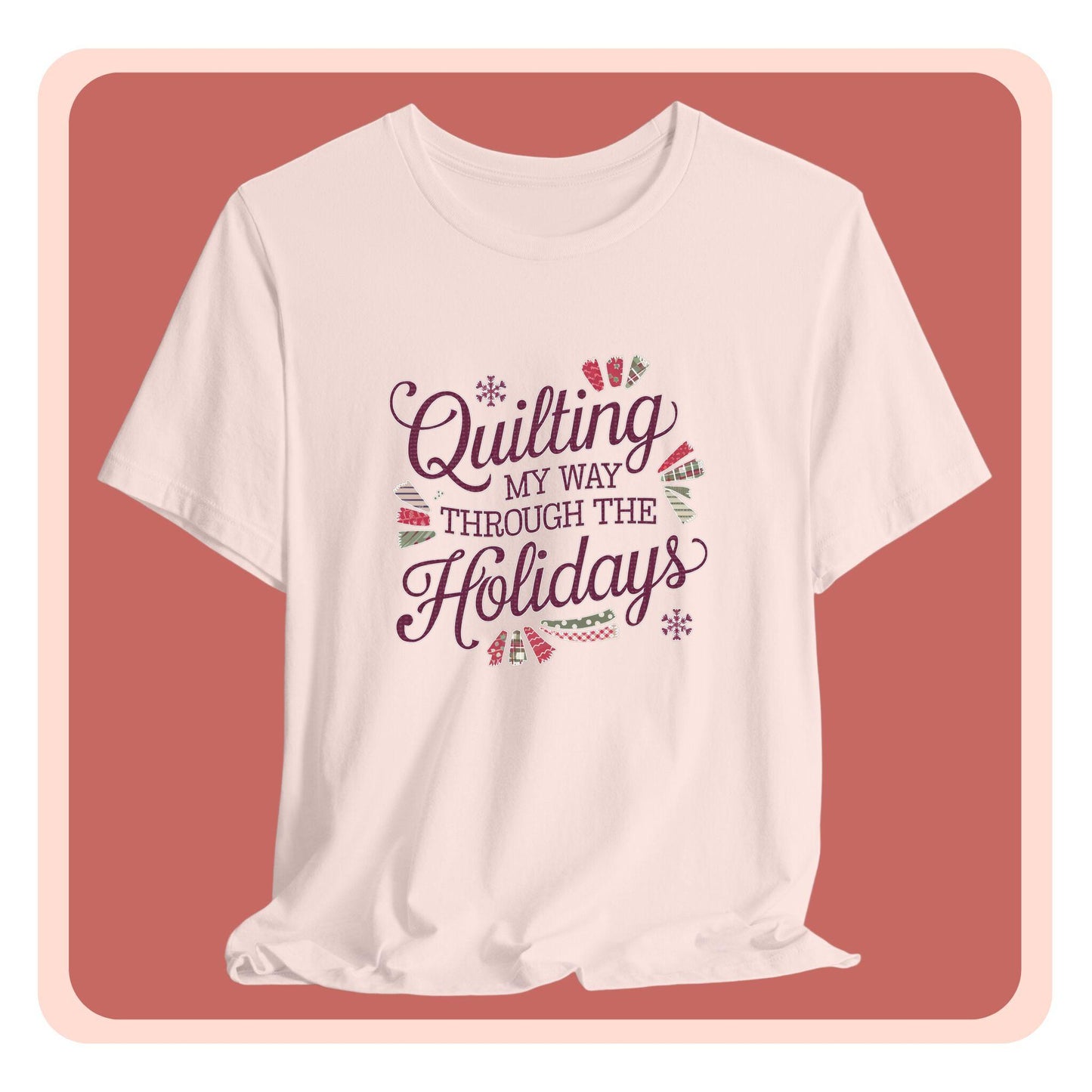 A playful holiday-themed t-shirt with the phrase "Quilting My Way Through the Holidays" surrounded by quilting-inspired decorations like fabric swatches and snowflakes.