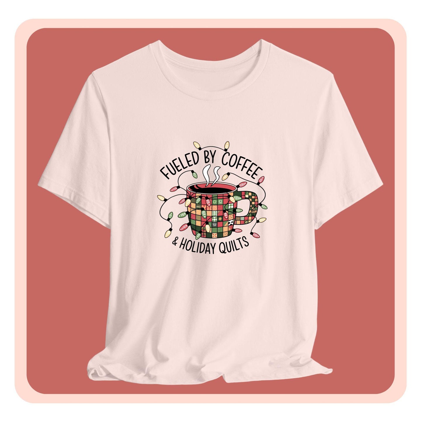 A christmas quilting t-shirt featuring a cozy coffee mug covered in patchwork quilt patterns, wrapped in festive holiday lights, with the phrase "Fueled by Coffee & Holiday Quilts" surrounding the design.