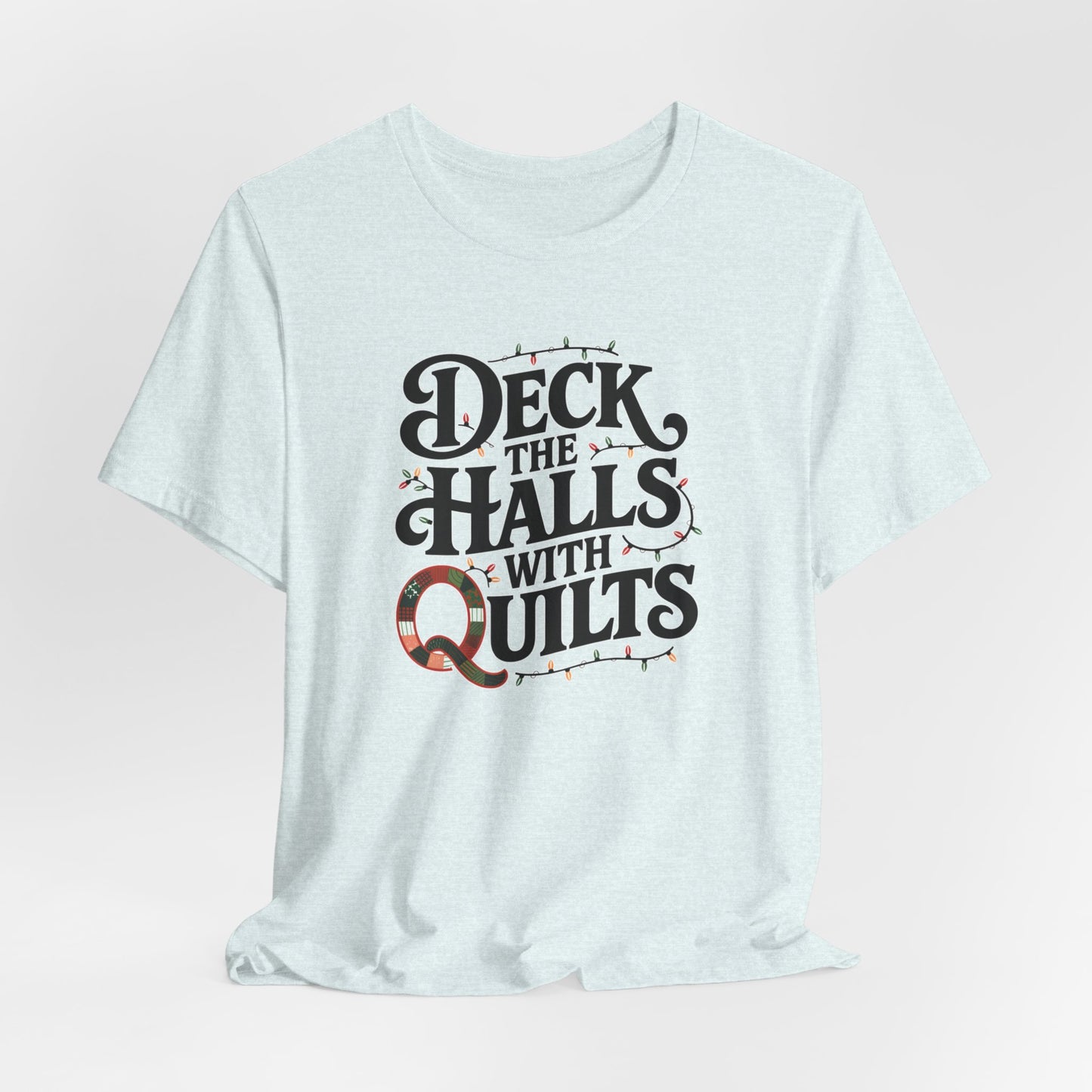 A Heather Ice Blue christmas quilting t-shirt featuring the phrase "Deck the Halls with Quilts," adorned with holiday lights and quilting-inspired elements, including a quilted 'Q' for a humorous touch.