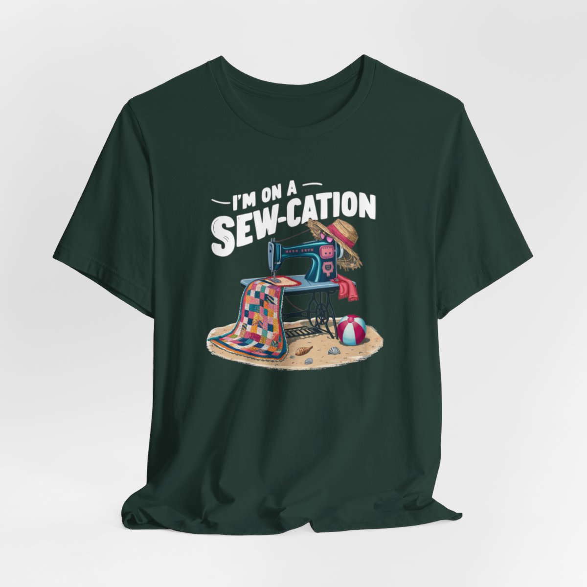 A Forest fun Quilting T-shirt of a vintage sewing machine on a beach with a colorful quilt, sun hat, and beach ball. Text above reads "I'm on a Sew-cation" in bold letters.