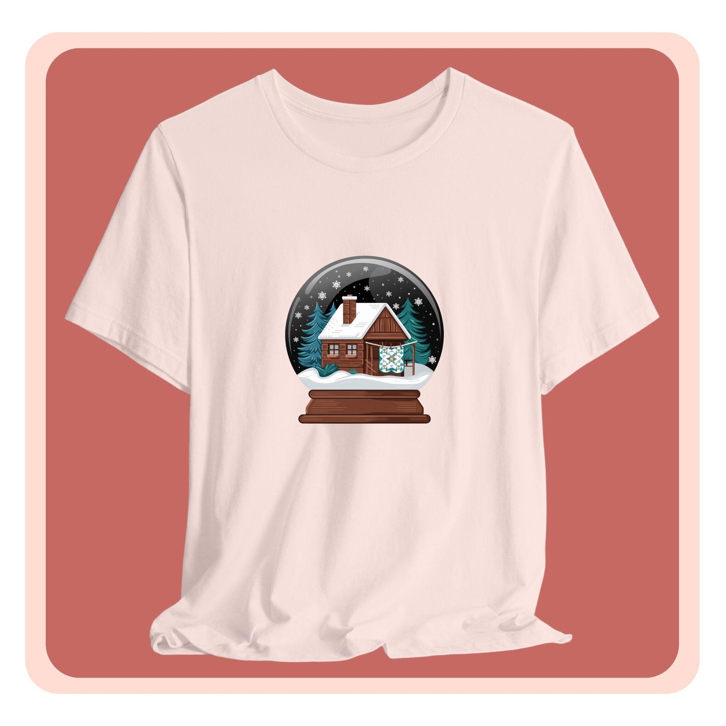A christmas quilting t-shirt featuring a cozy log cabin covered in snow, with a quilt hanging outside, set inside a snow globe with swirling snowflakes, blending quilting and holiday warmth.