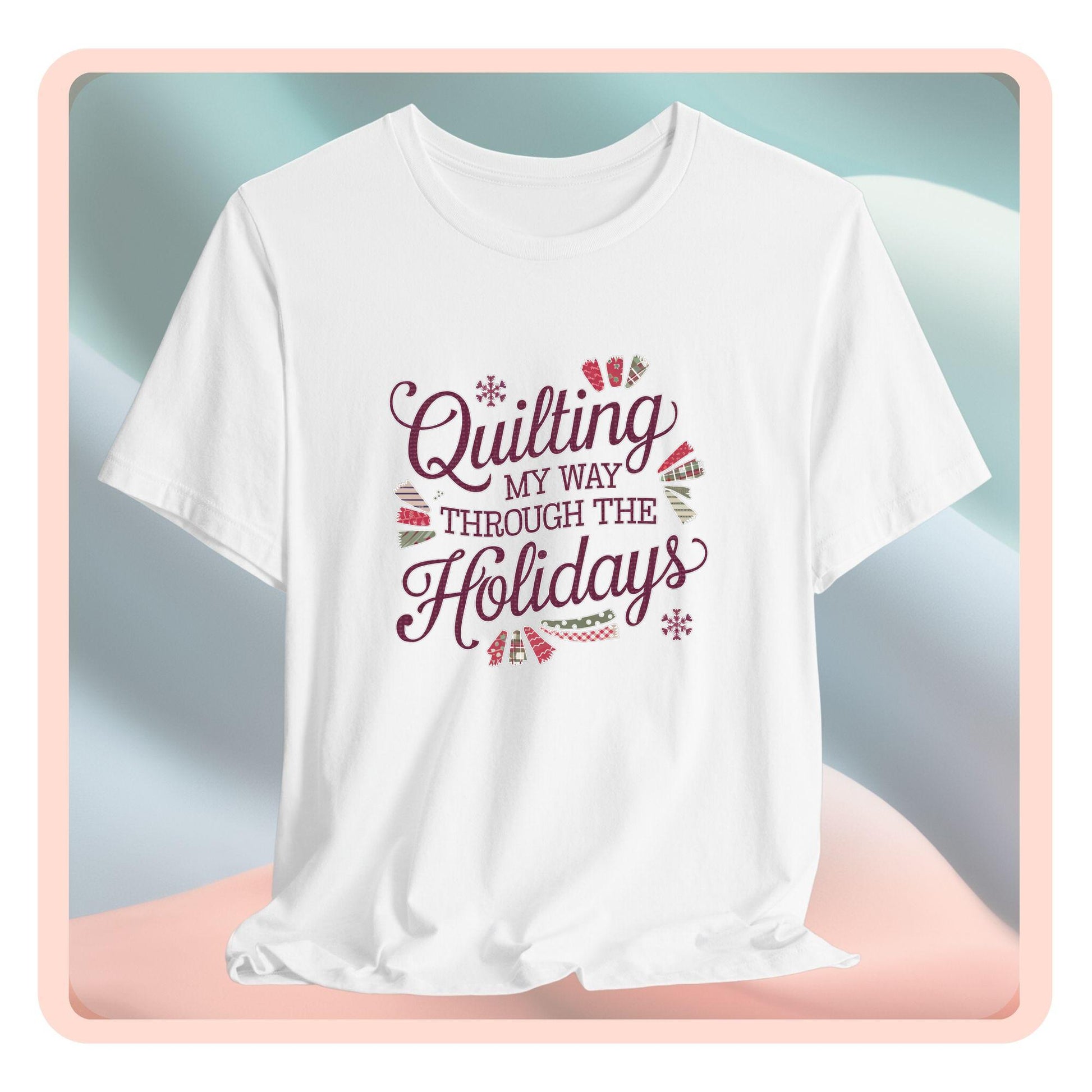A playful holiday-themed t-shirt with the phrase "Quilting My Way Through the Holidays" surrounded by quilting-inspired decorations like fabric swatches and snowflakes.
