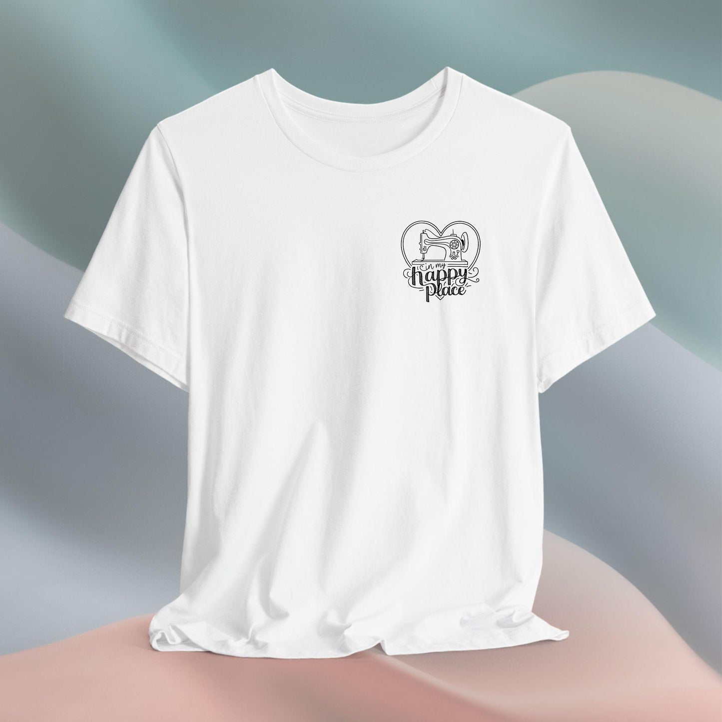 A funny quilting T-shirt design showing a sewing machine inside a heart shape with decorative swirls. Text reads "In my happy place" in mixed fonts, emphasizing quilting as a source of joy and contentment for enthusiasts.