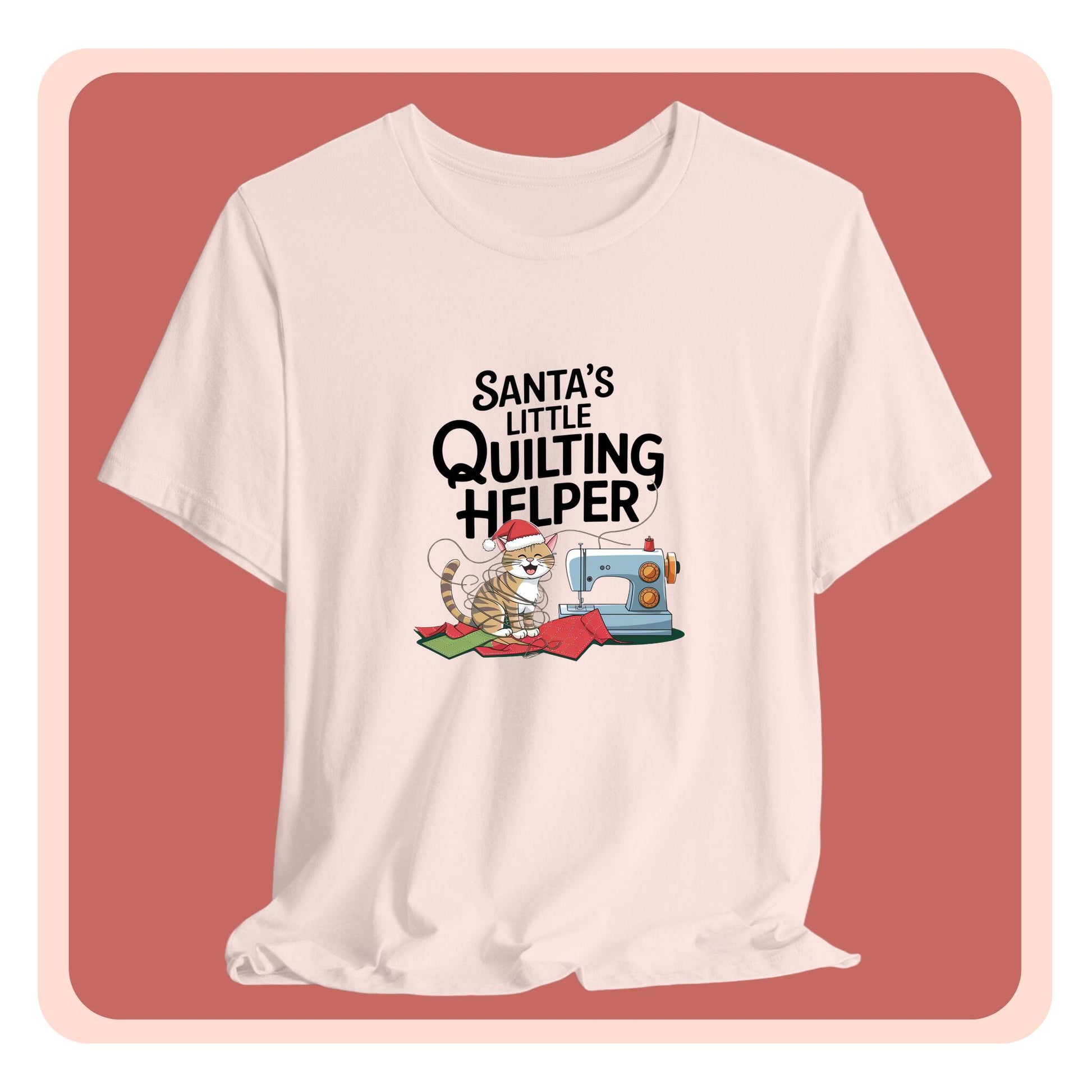A christmas quilting t-shirt featuring a playful cat wearing a Santa hat is tangled in thread next to a sewing machine, with the phrase "Santa's Little Quilting Helper" above, combining quilting and holiday humor.