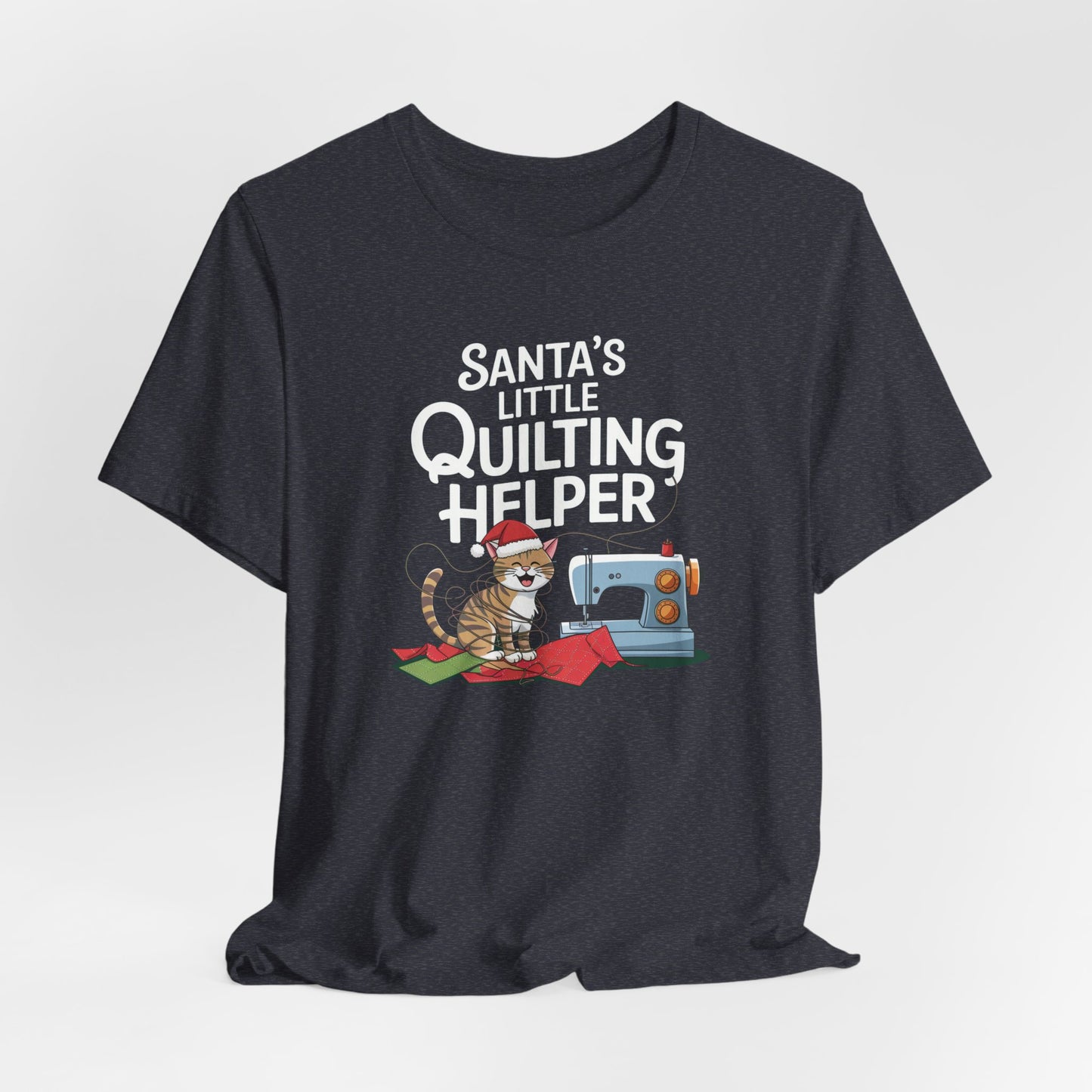 A Heather Navy christmas quilting t-shirt featuring a playful cat wearing a Santa hat is tangled in thread next to a sewing machine, with the phrase "Santa's Little Quilting Helper" above, combining quilting and holiday humor.