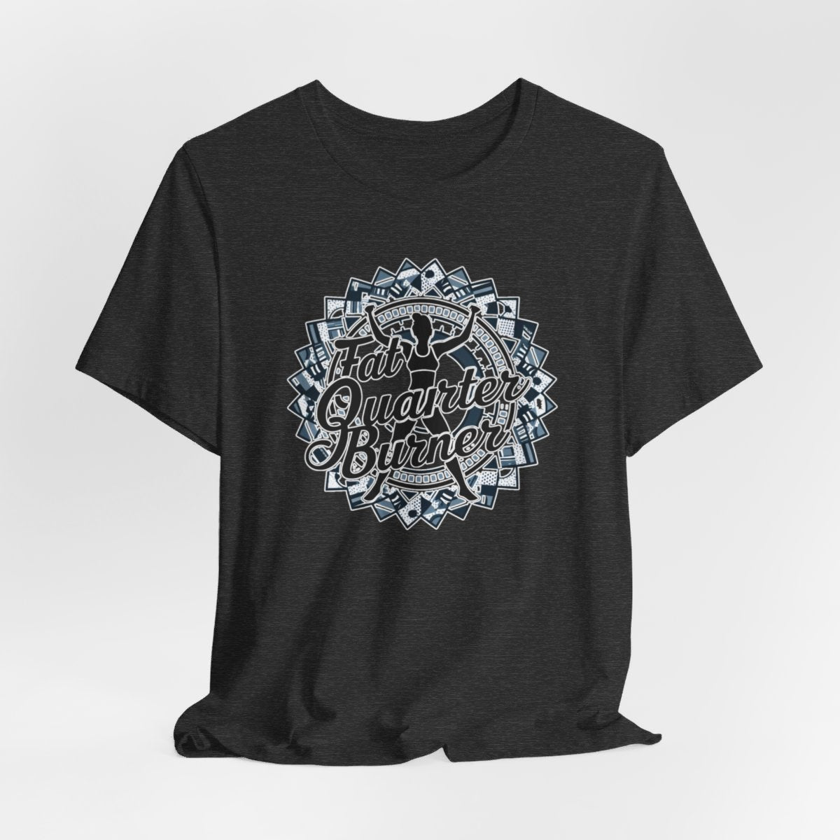 A Dark Grey Heather T-Shirt featuring a patchwork border surrounding silhouette of woman lifting weights. Text reads "Fat Quarter Burner" in bold script.