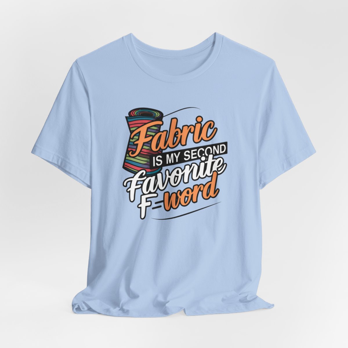 A Baby Blue T-Shirt with the phrase Fabric is My Second Favorite F-Word in a bold font next to a bolt of fabric