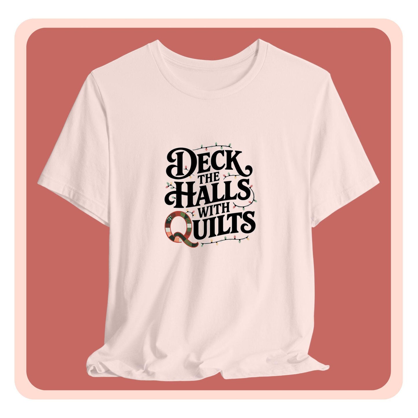 A christmas quilting t-shirt featuring the phrase "Deck the Halls with Quilts," adorned with holiday lights and quilting-inspired elements, including a quilted 'Q' for a humorous touch.