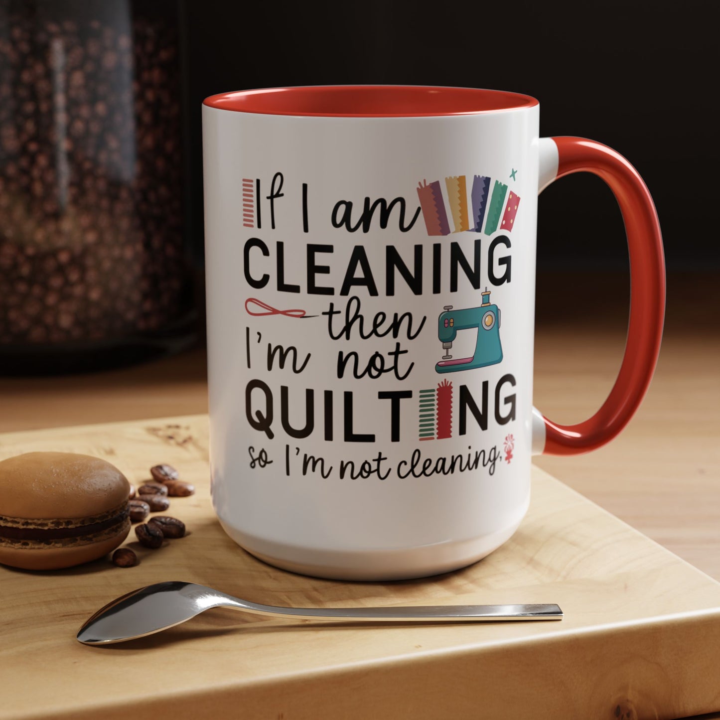 A funny Ceramic Mug with the phrase If I am Cleaning then I'm not Quilting in a bold and cheerful font with images of quilting icons and supplies