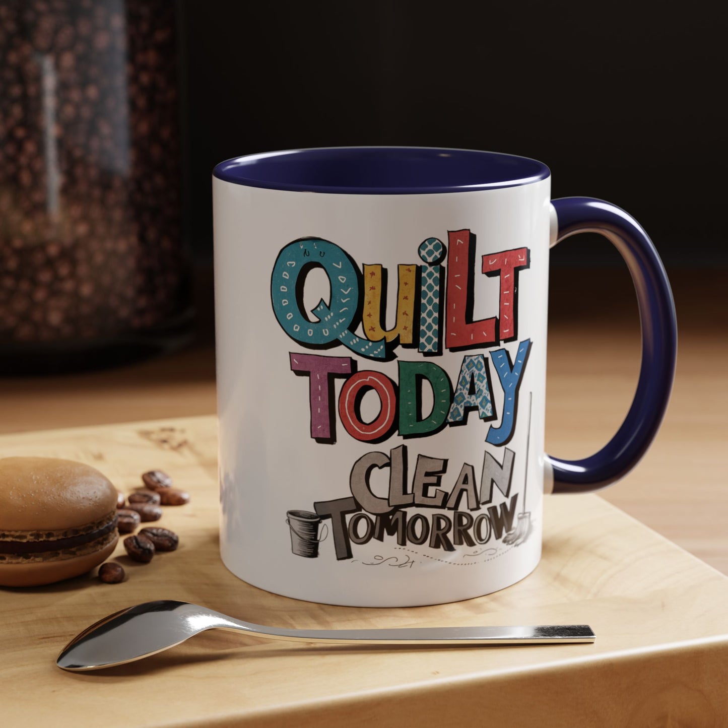 A funny Ceramic Mug with the phrase Quilt Today, Clean Tomorrow in a bold and cheerful font with a broom off to the side
