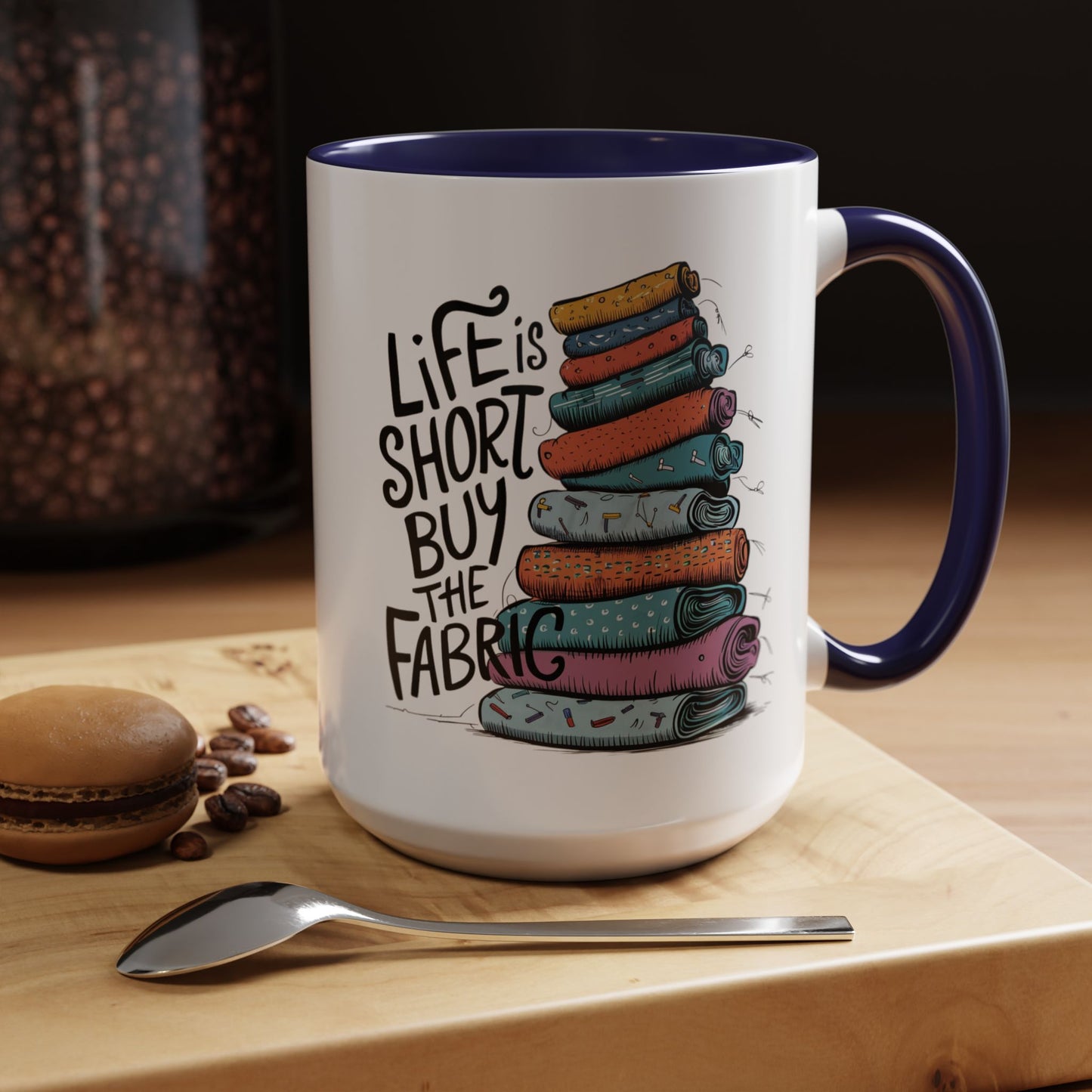 A funny Ceramic Mug with the phrase Life is Short, Buy the Fabric with the label 'Life is Short, Buy the Fabric' next to a graphic of A funny pile of fabric