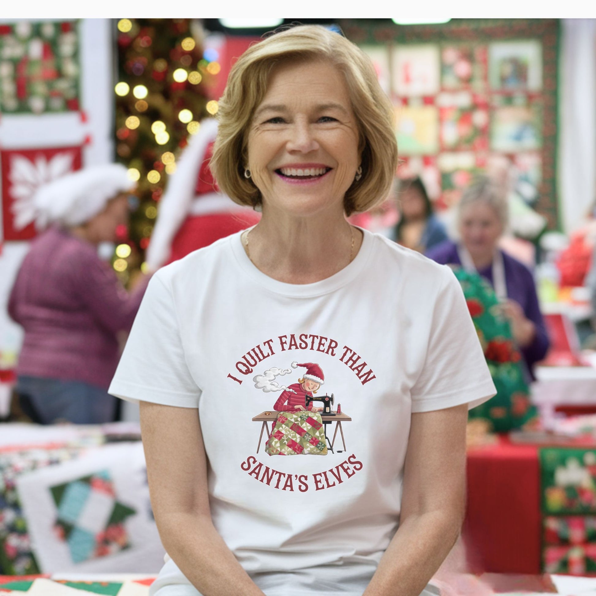A christmas quilting t-shirt featuring  a quilter working at a sewing machine, quilting a festive holiday quilt, with the phrase "I Quilt Faster Than Santa's Elves" above the image, highlighting the speed and skill of the quilter.