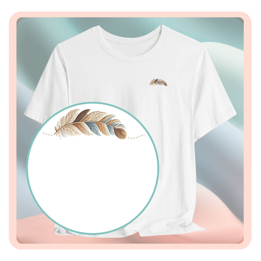 A T-Shirt featuring an illustration of a curving feather simulating patterned sections, resembling a patchwork quilt. The feather features a mix of floral, polka dot, and geometric designs in shades of blue, brown, and pink, with a dotted line tracing its path.