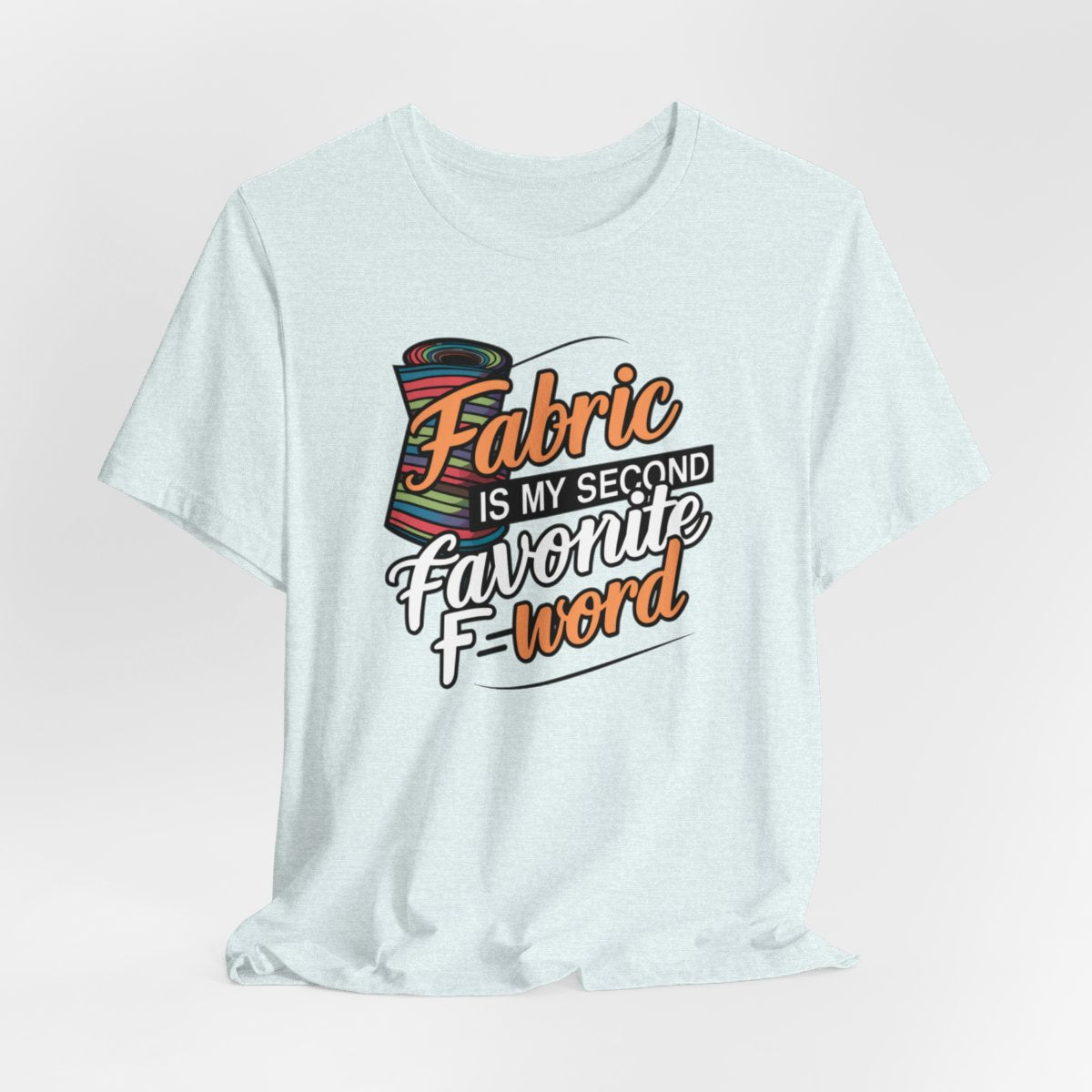 A Heather Ice Blue T-Shirt with the phrase Fabric is My Second Favorite F-Word in a bold font next to a bolt of fabric