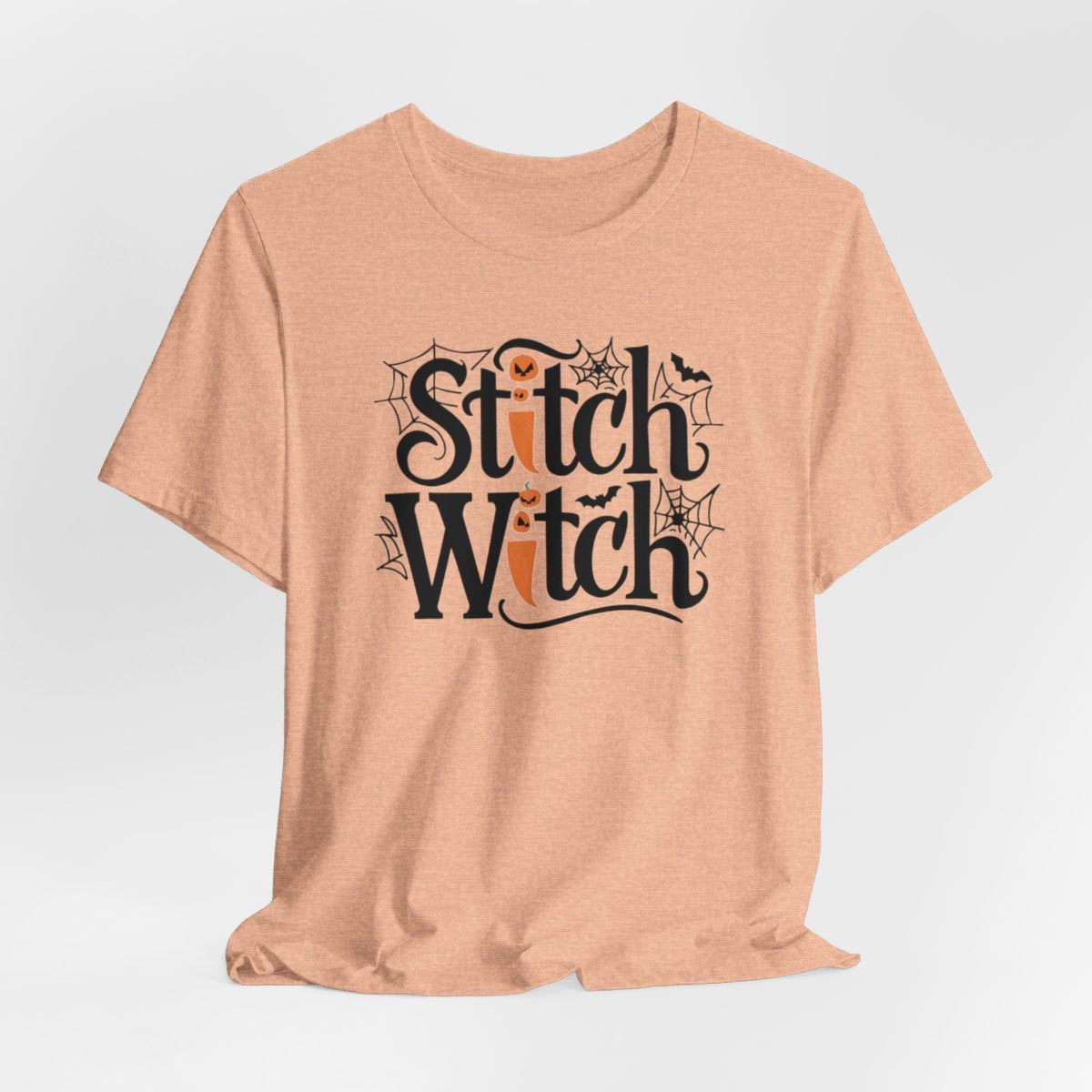 T-shirt design with "Stitch Witch" text in Halloween-themed typography. Jack-o'-lanterns, spiderwebs, and bats decorate the letters. The "i" in "Stitch" resembles a sewing needle. Ideal for quilters who love Halloween.