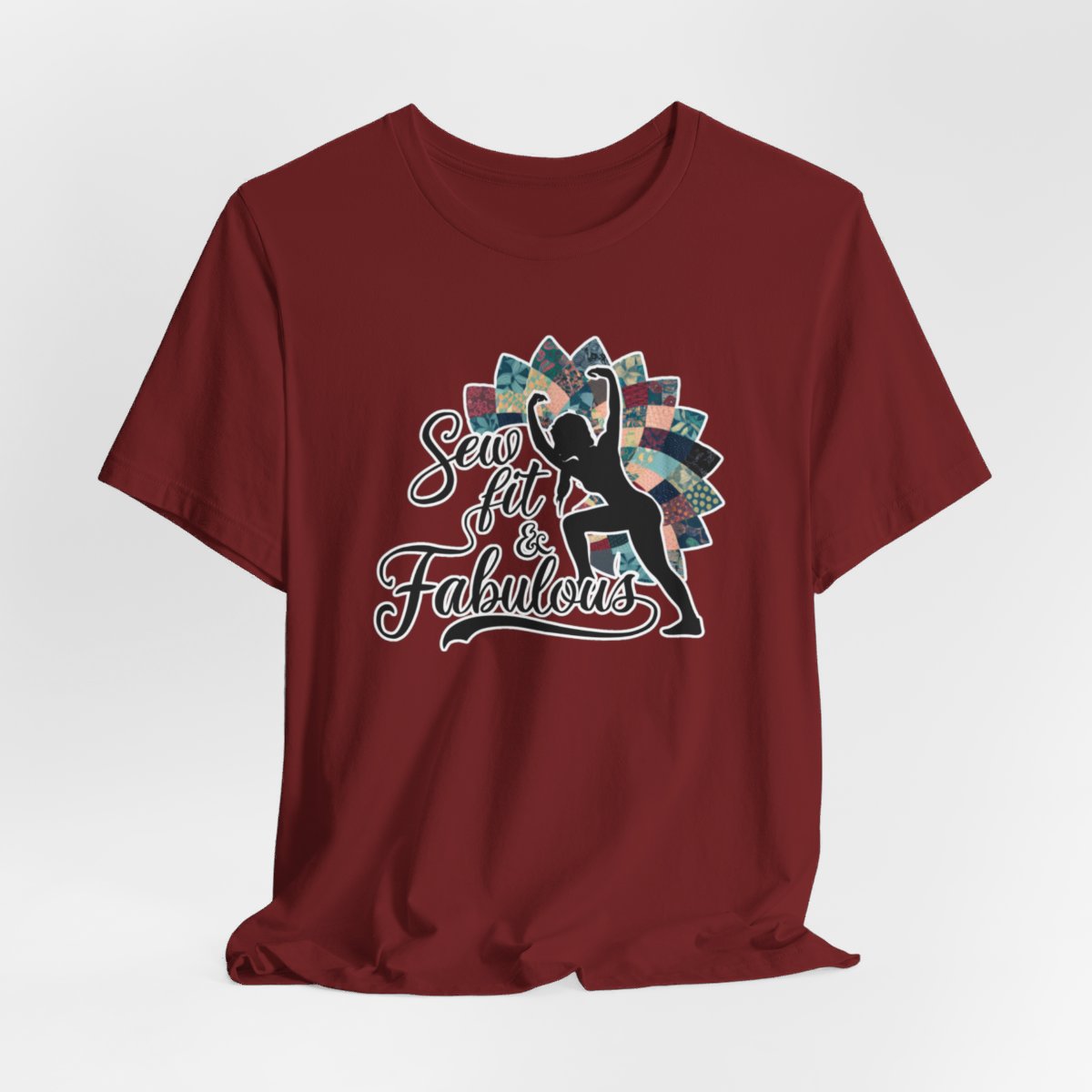 A Cardinal T-Shirt featuring a black silhouette of woman with raised arms against colorful patchwork background. Text reads "Sew fit & Fabulous" in stylized script.