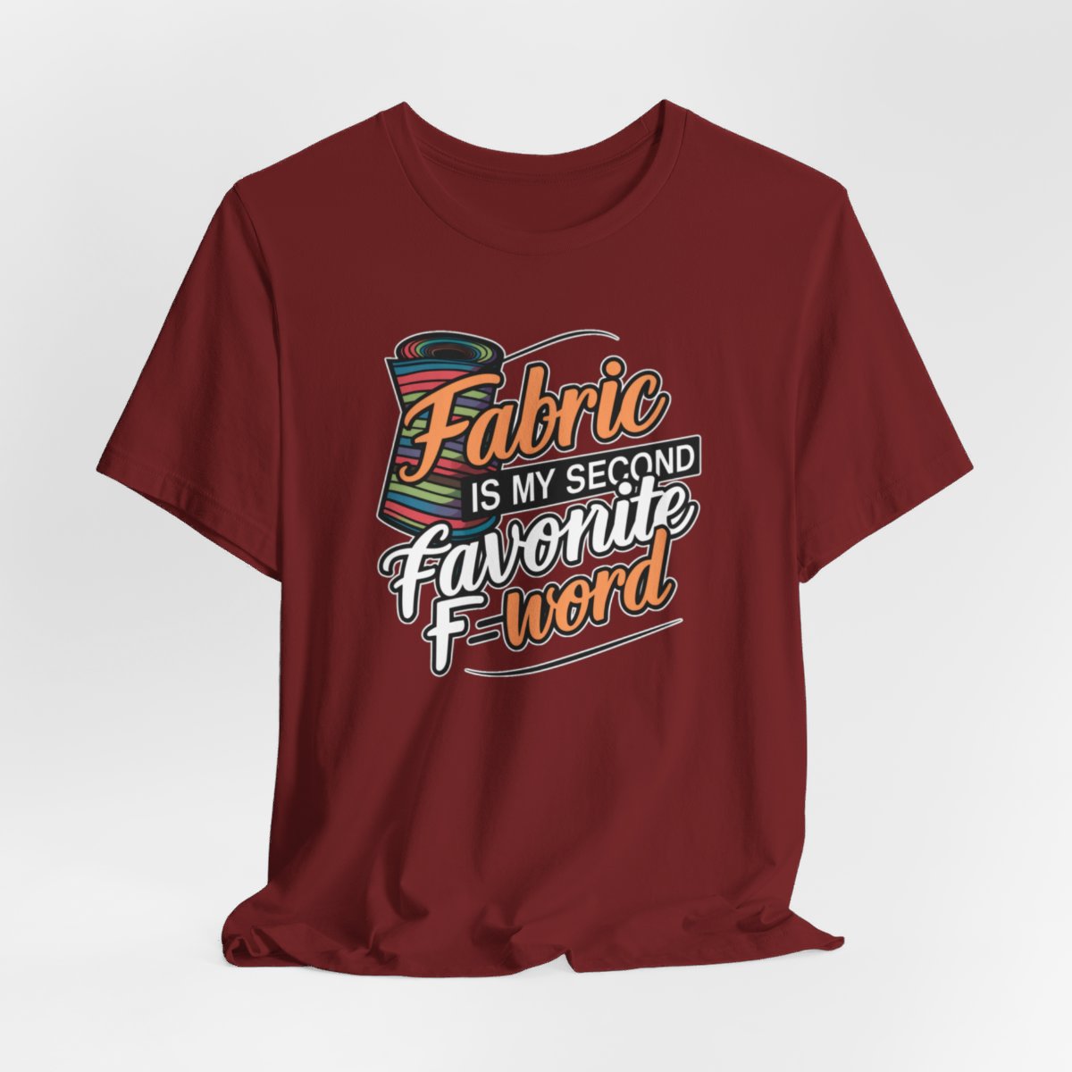 A Cardinal T-Shirt with the phrase Fabric is My Second Favorite F-Word in a bold font next to a bolt of fabric