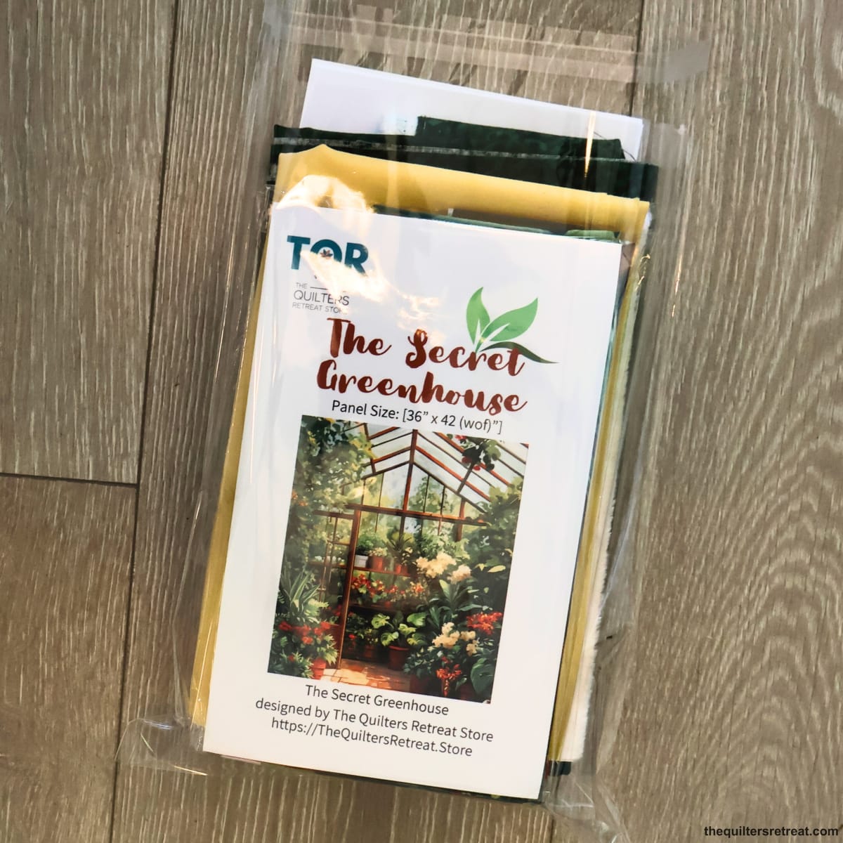 Packaged Secret Greenhouse quilt kit — the greenhouse panel and fabrics with the pattern, panel size 36x42