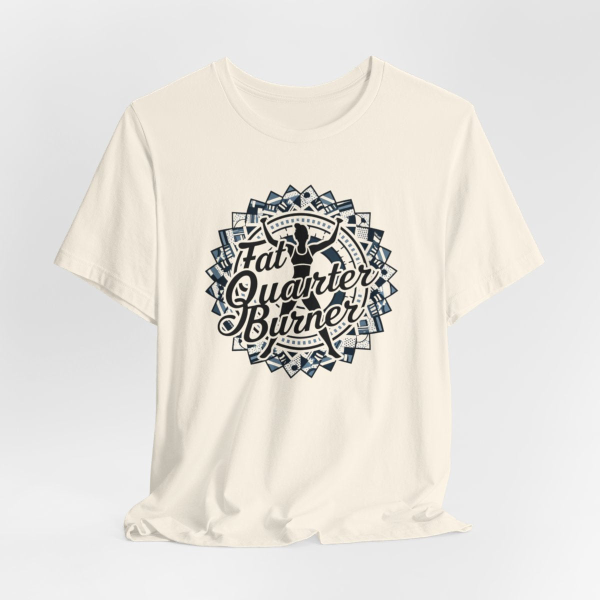A Natural T-Shirt featuring a patchwork border surrounding silhouette of woman lifting weights. Text reads "Fat Quarter Burner" in bold script.