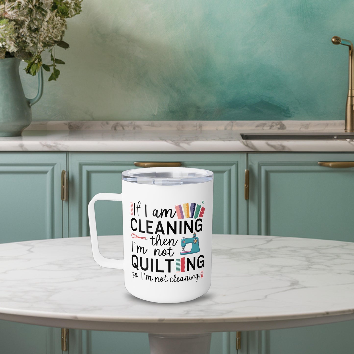 A funny quilting-inspired Insulated Mug with the phrase If I am Cleaning then I'm not Quilting in a bold and cheerful font with images of quilting icons and supplies