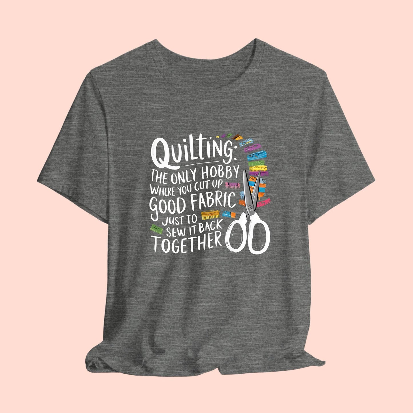 A Quilting-themed T-Shirt with text "Quilting: The Only Hobby Where You Cut Up Good Fabric Just to Sew it Back Together" surrounded by colorful fabric scraps and scissors.