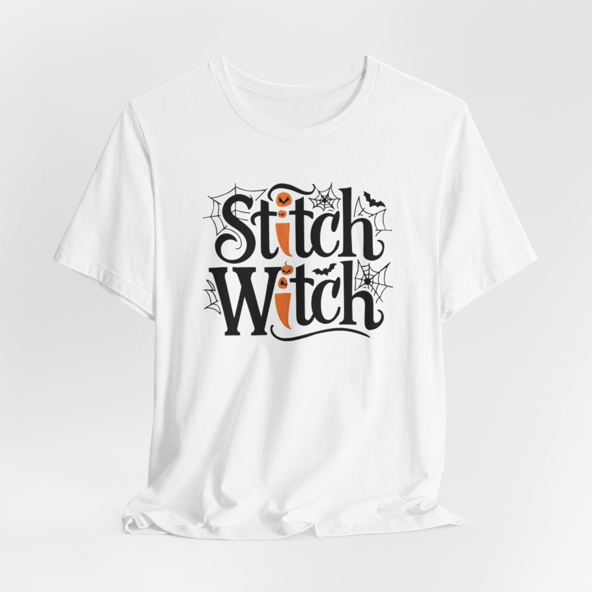 T-shirt design with "Stitch Witch" text in Halloween-themed typography. Jack-o'-lanterns, spiderwebs, and bats decorate the letters. The "i" in "Stitch" resembles a sewing needle. Ideal for quilters who love Halloween.