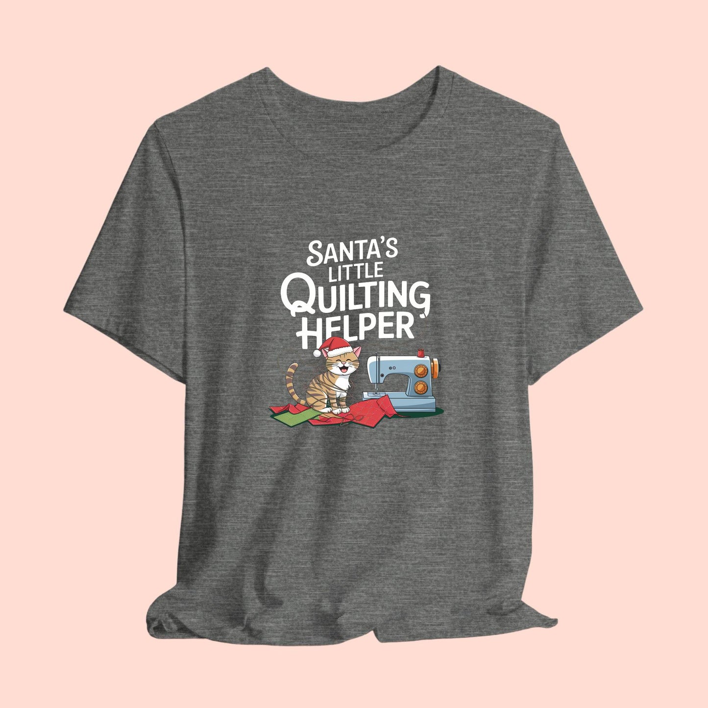 A christmas quilting t-shirt featuring a playful cat wearing a Santa hat is tangled in thread next to a sewing machine, with the phrase "Santa's Little Quilting Helper" above, combining quilting and holiday humor.