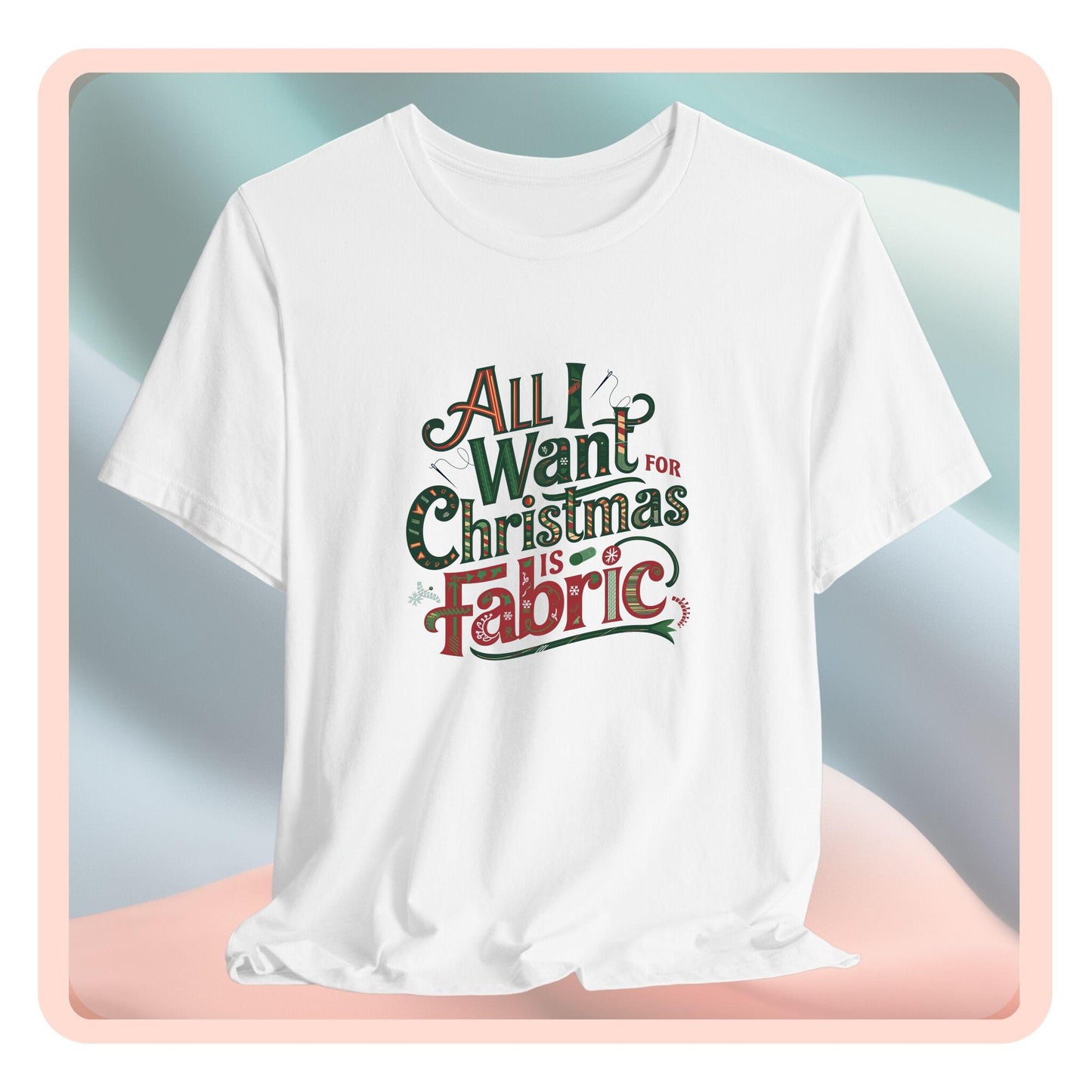 A festive quilting christmas T-shirt featuring the phrase "All I Want for Christmas is Fabric," with fun sewing and quilting accents like needles and threads swirling around the text.