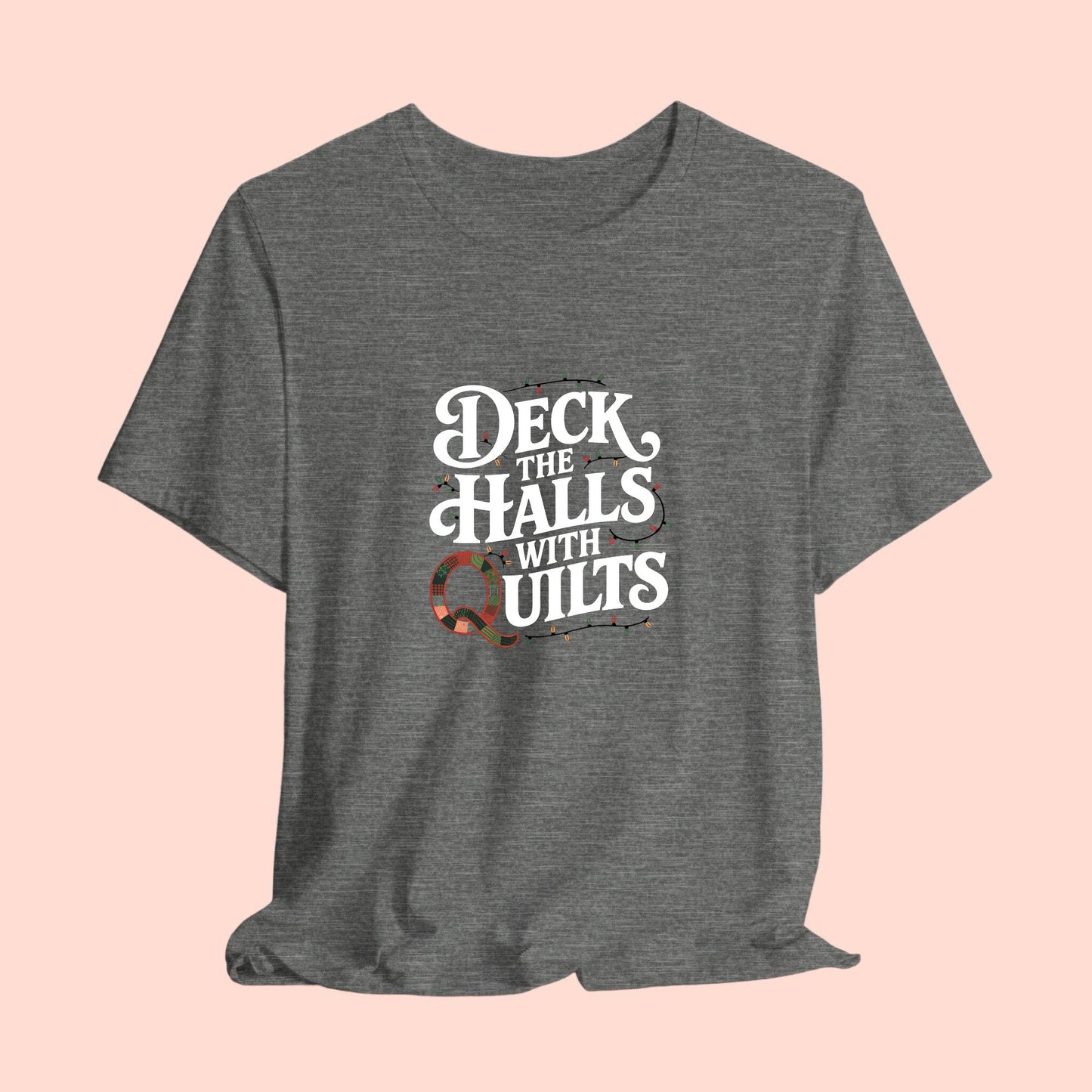 A christmas quilting t-shirt featuring the phrase "Deck the Halls with Quilts," adorned with holiday lights and quilting-inspired elements, including a quilted 'Q' for a humorous touch.
