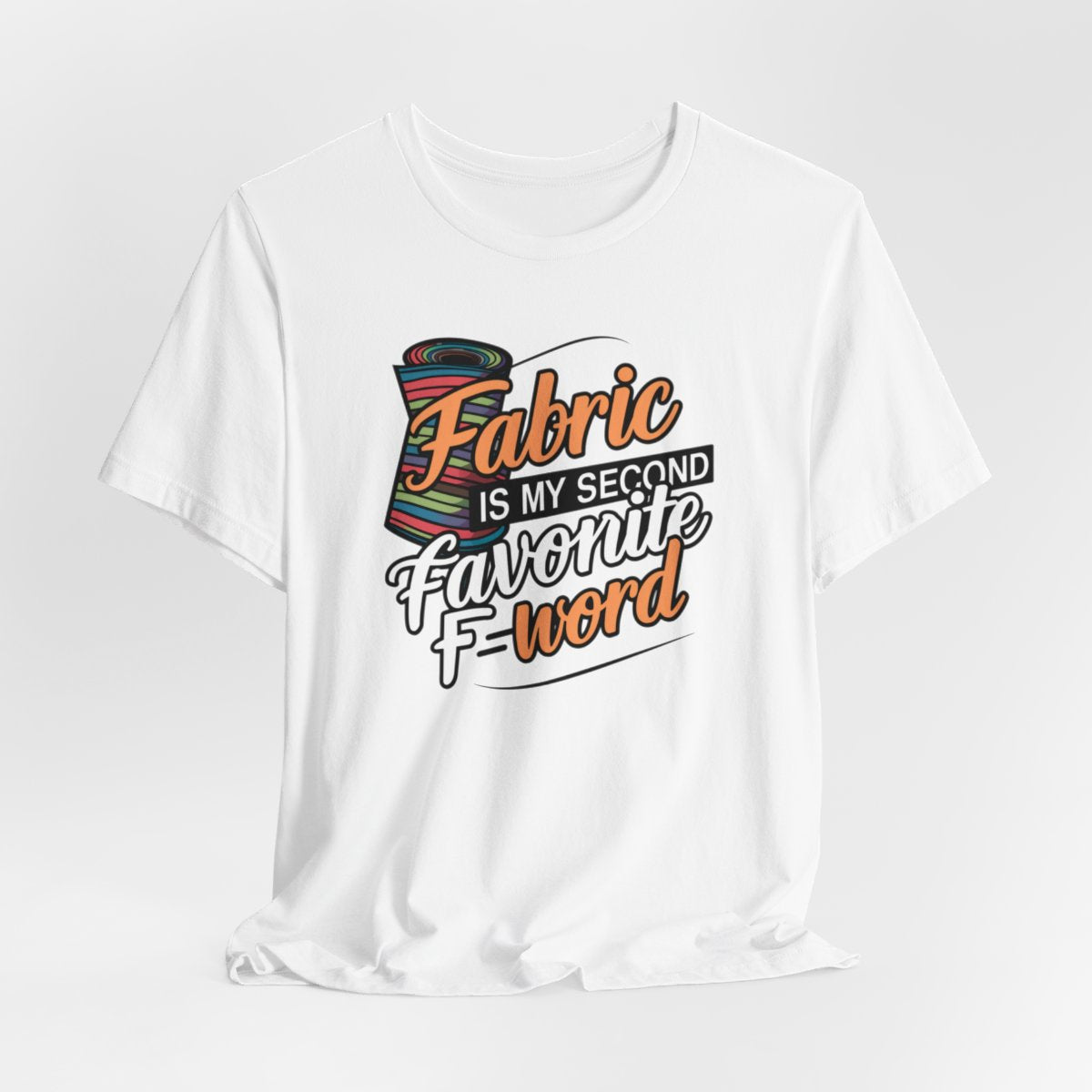 A White T-Shirt with the phrase Fabric is My Second Favorite F-Word in a bold font next to a bolt of fabric