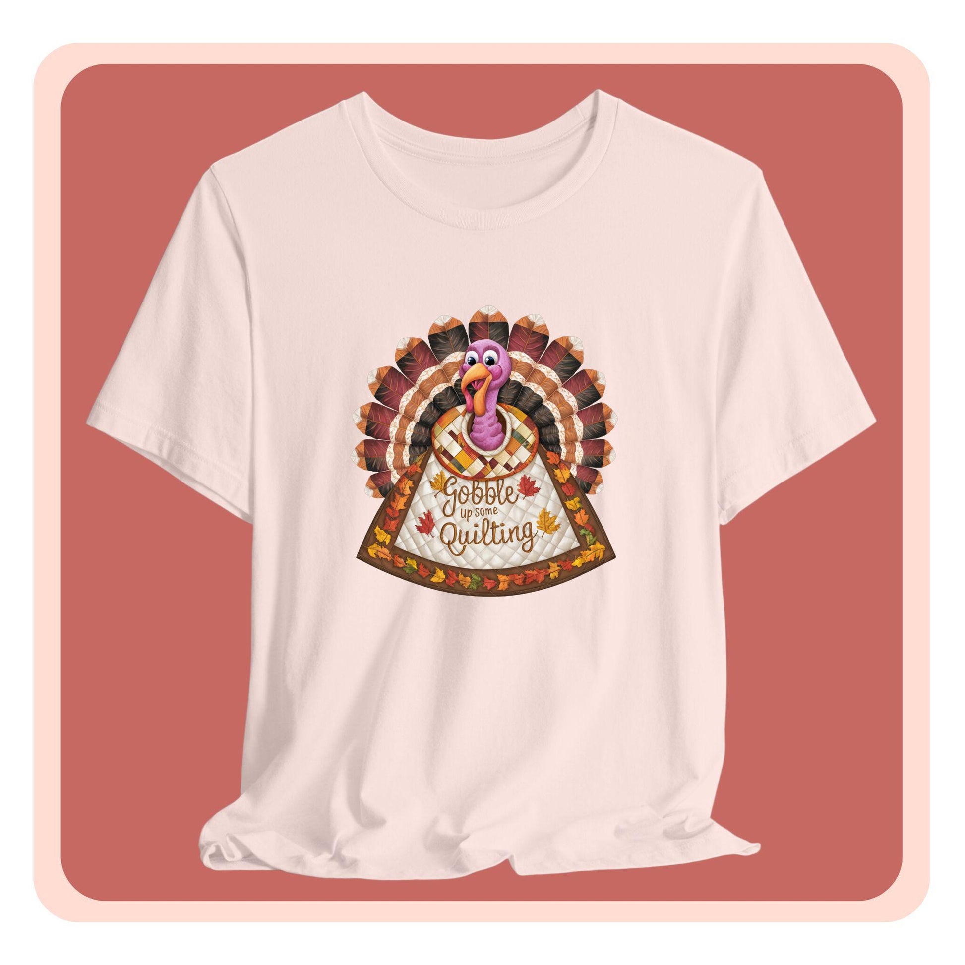 A thanksgiving  quilting t-shirt featuring a quilted turkey design with colorful patchwork feathers and body. Text on turkey reads "Gobble up some Quilting" surrounded by fall leaves. Combines Thanksgiving imagery with quilting motifs in a whimsical illustration.