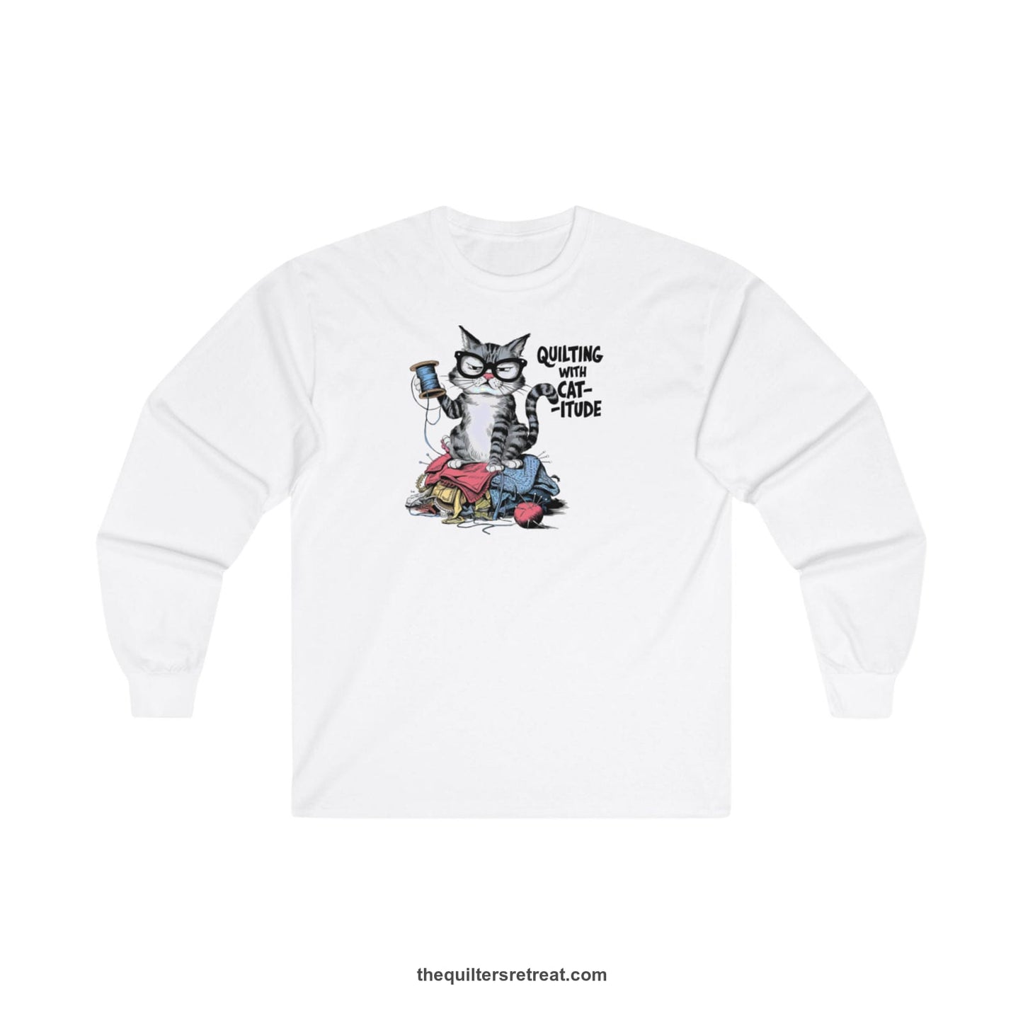 A White Long Sleeve T-Shirt with a grumpy cat holding thread spool atop fabric pile with "Quilting with Cat-itude" text