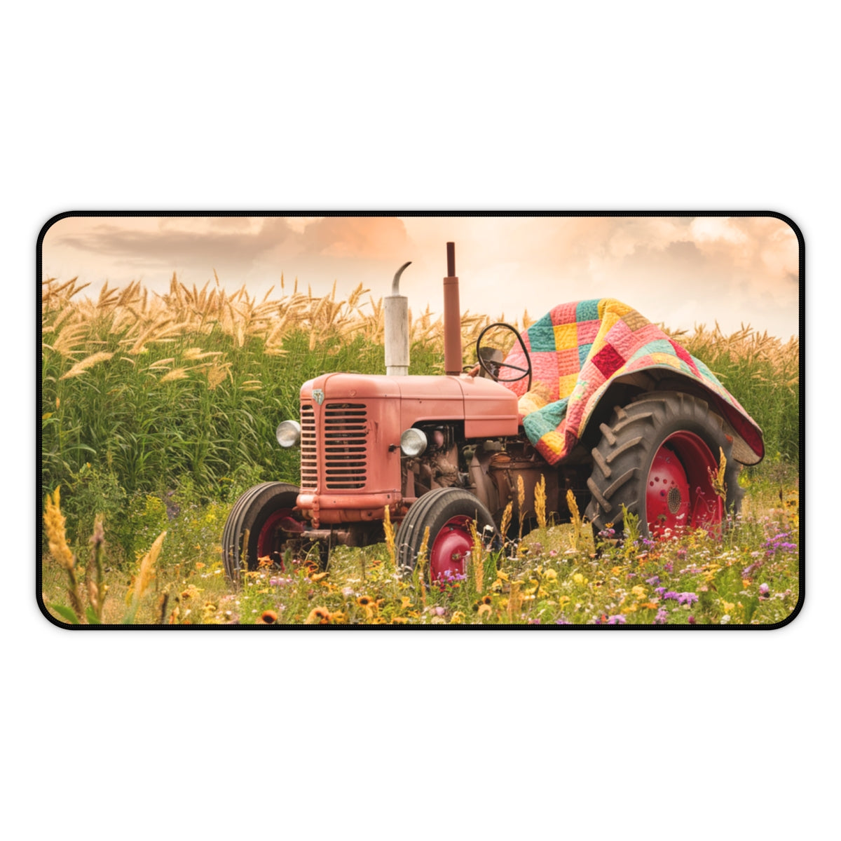 A quilting inspired Desk pad featuring a Vintage  tractor in a wildflower field, partially covered by a colorful patchwork quilt. Golden wheat stalks and a sunset sky create a warm, countryside atmosphere. Perfect gift for quilters.