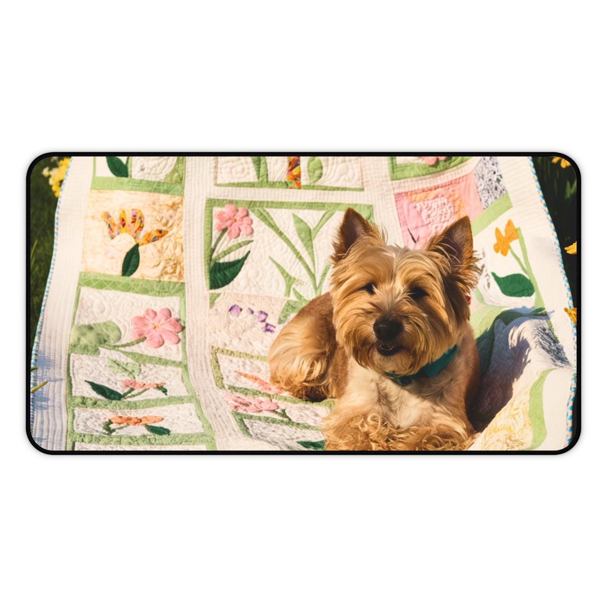 A quilting inspired Desk pad design showing a terrier puppy sitting on a colorful spring-themed quilt with various flower patterns. The quilt features pink, yellow, and green patches with intricate floral designs, creating a cheerful and vibrant workspace accessory. Perfect gift for quilters.