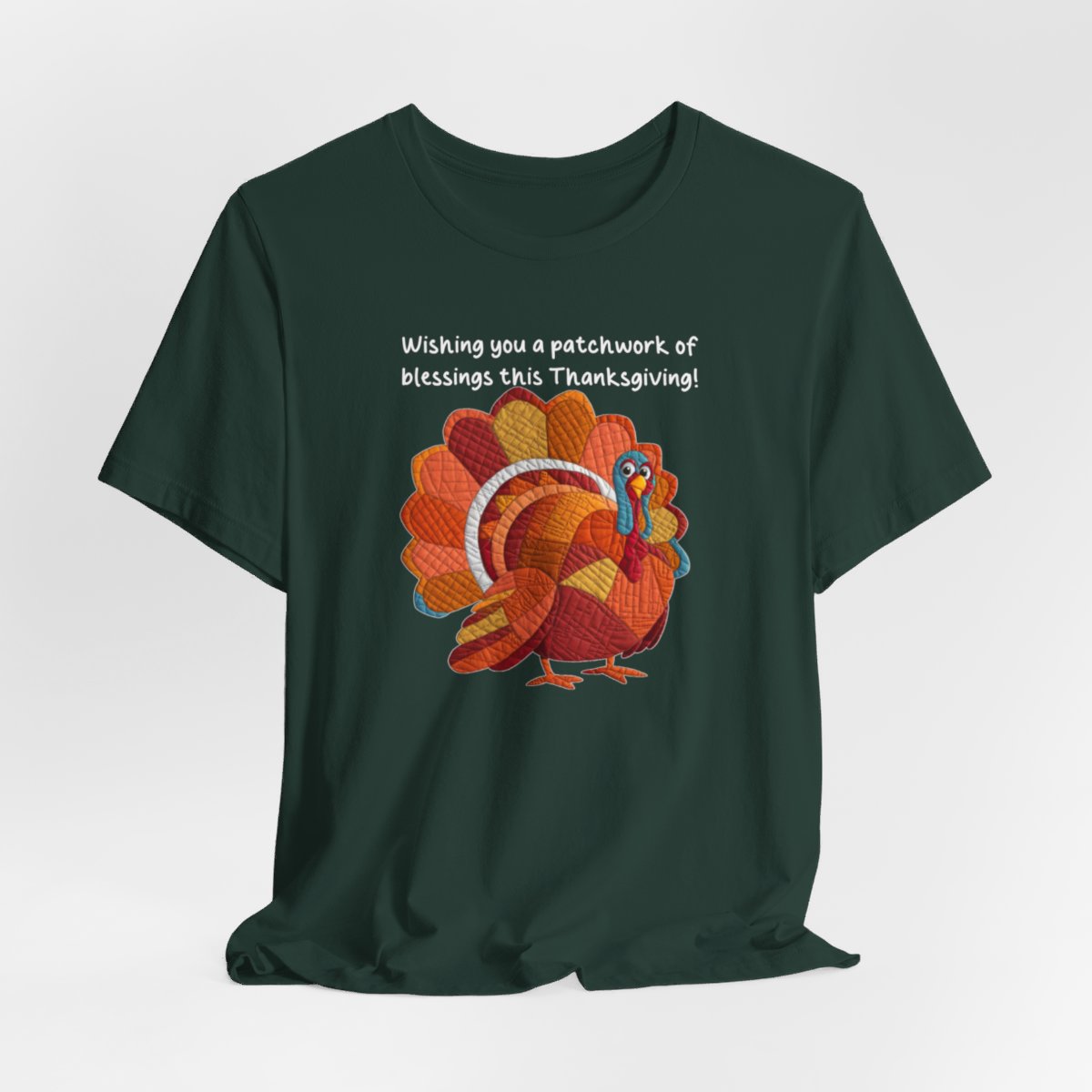 A Forest thanksgiving quilting t-shirt featuring a quilted patchwork turkey in autumn colors with text "Wishing you a patchwork of blessings this Thanksgiving!" Turkey features various quilt patterns and textures in shades of orange, red, yellow, and blue. Whimsical, crafty holiday design perfect for quilting enthusiasts.