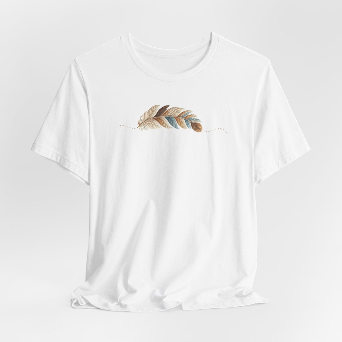 A White T-Shirt with an illustration of a curving feather simulating patterned sections, resembling a patchwork quilt. The feather features a mix of floral, polka dot, and geometric designs in shades of blue, brown, and pink, with a dotted line tracing its path.