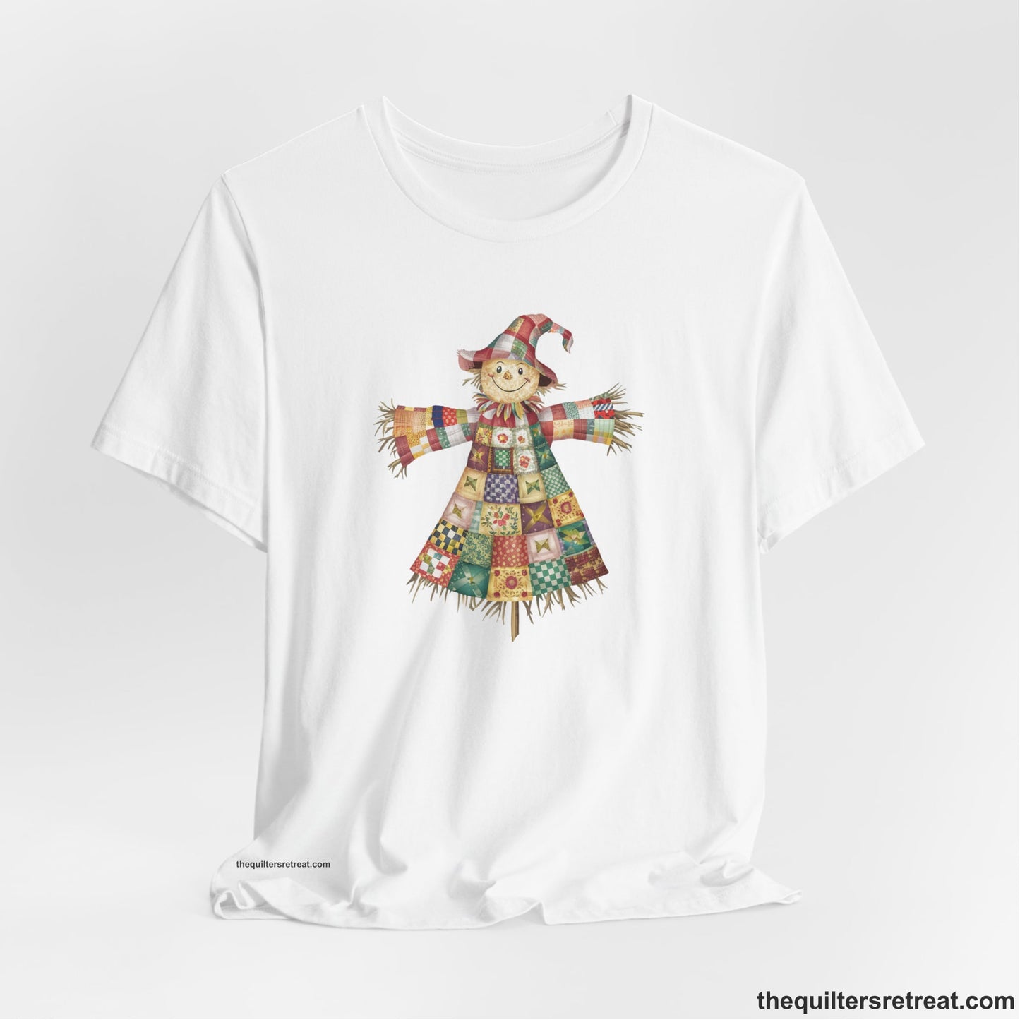 A White Short Sleeve T-Shirt with a patchwork scarecrow with a cheerful face in a whimsical style
