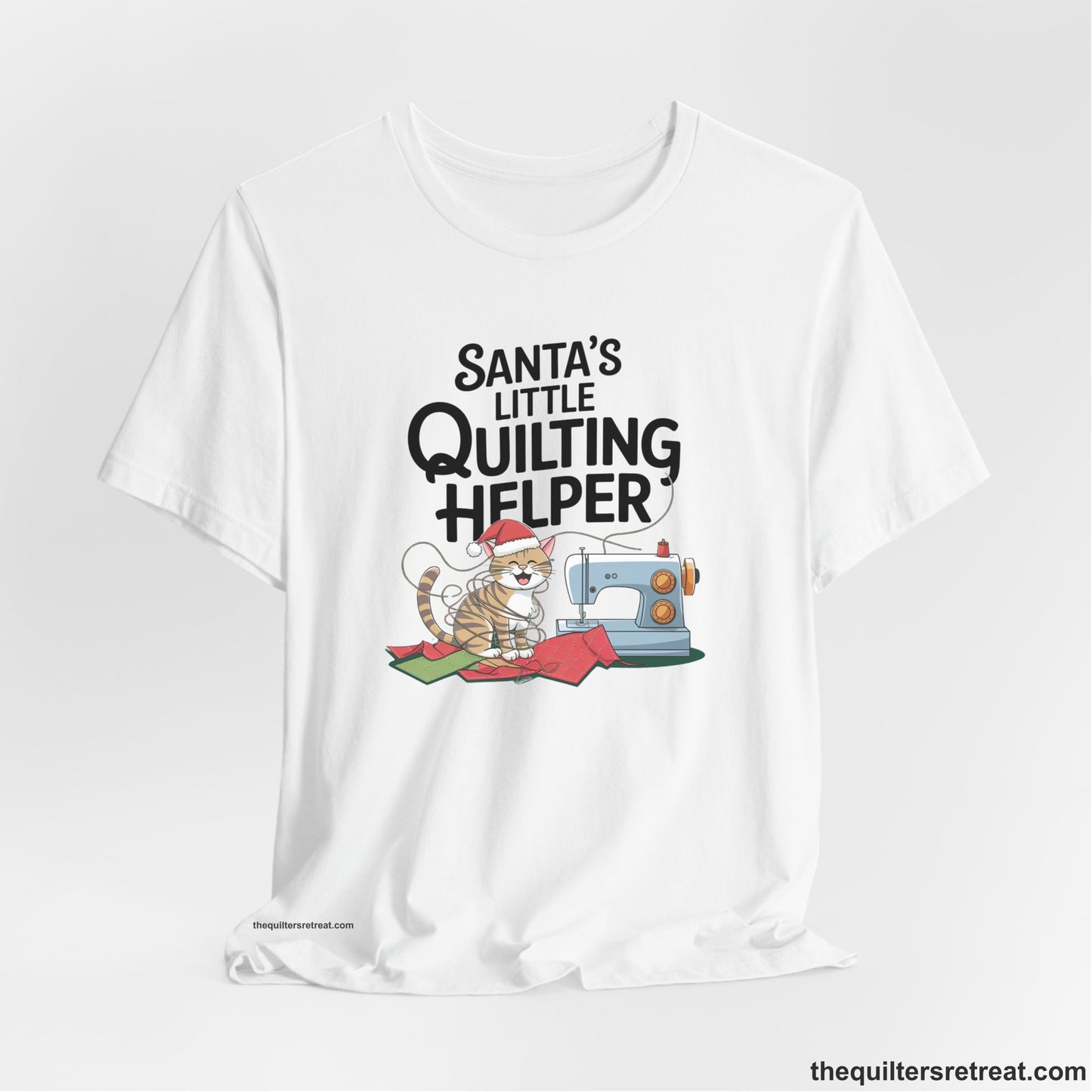 A White Short Sleeve T-Shirt with a santa-hat-wearing kitten with a sewing machine and "Santa's Little Quilting Helper" text in playful style