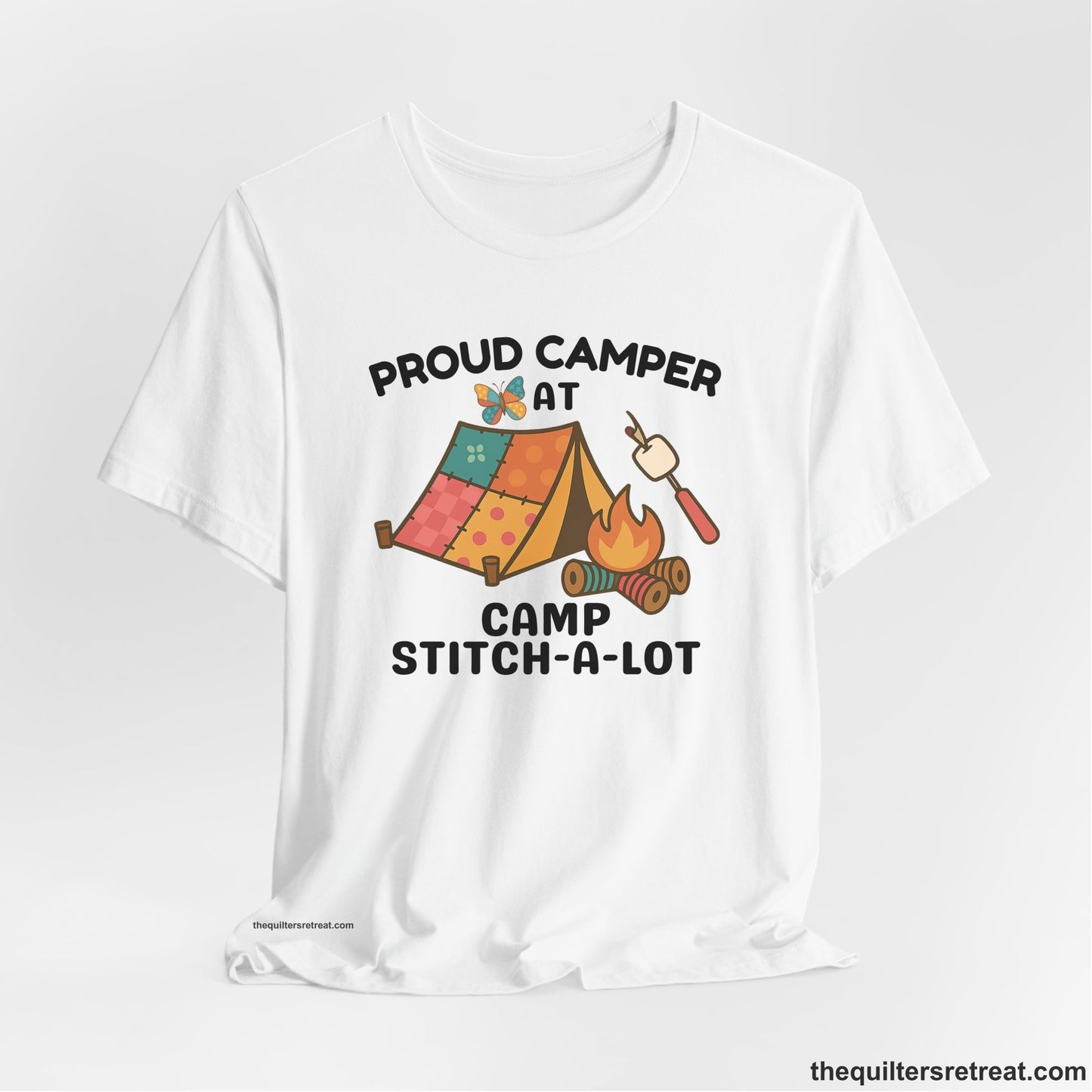 A White Short Sleeve T-Shirt with a camping scene with patchwork tent, campfire, and whimsical butterfly and marshmallow illustration