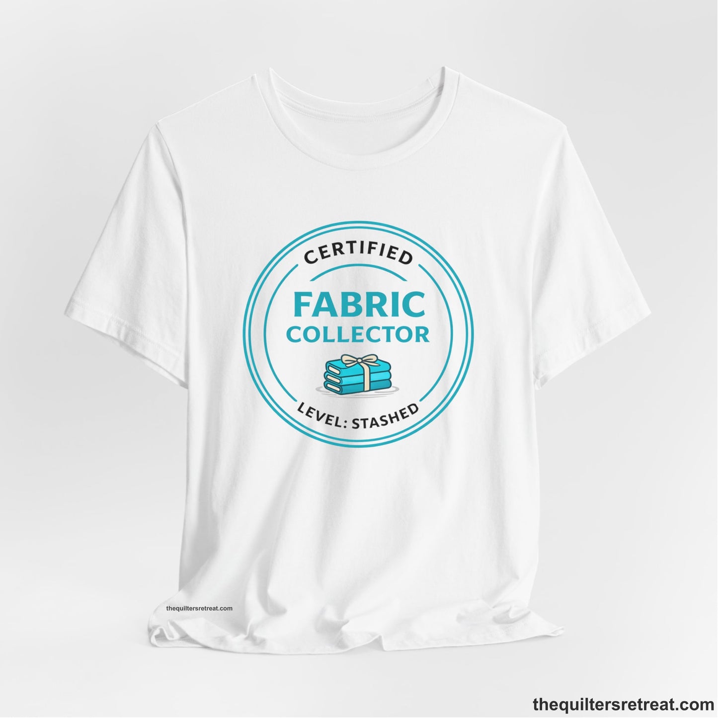 A White Short Sleeve T-Shirt with a Circular teal logo with a whimsical fabric stack design, text "Fabric Collector".