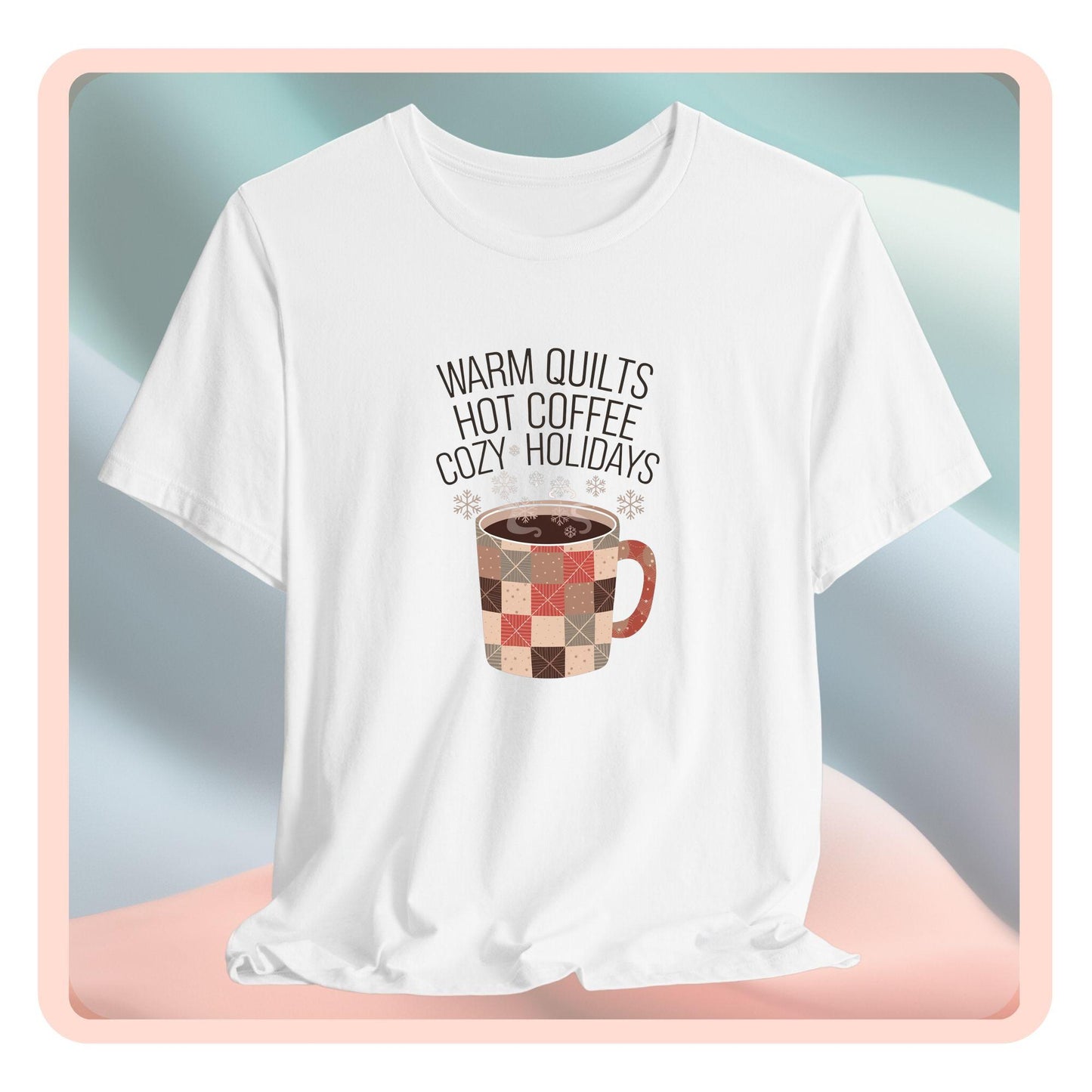 A christmas quilting t-shirt featuring a cozy patchwork quilt-themed coffee mug, surrounded by snowflakes, with the phrase "Warm Quilts, Hot Coffee, Cozy Holidays" above the mug, celebrating the warmth of quilts and coffee during the holiday season.