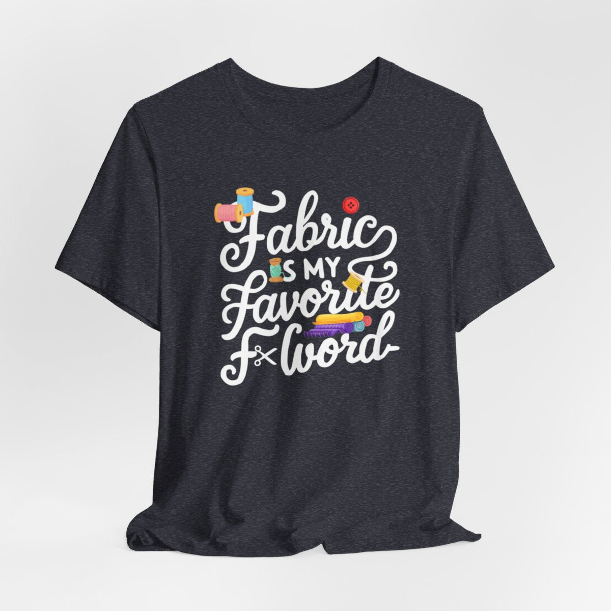 A Heather Navy T-Shirt with the phrase Fabric is My Favorite F-Word in a bold font with thread, buttons, and fabric bolts