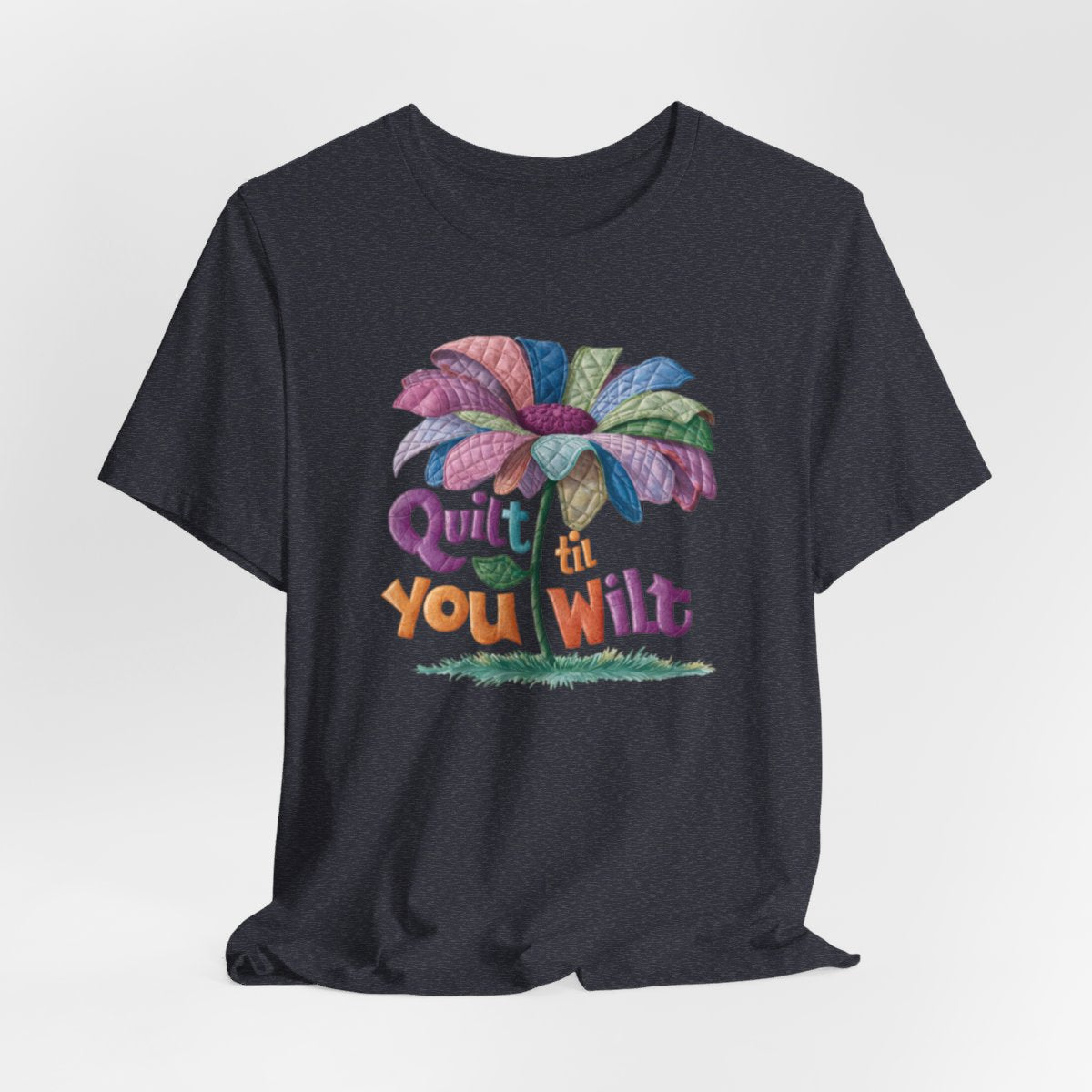 A Heather Navy funny quilting T-Shirt with the phrase Quilt 'Till You Wilt showing a cheerful, but slightly wilted quilted flower design