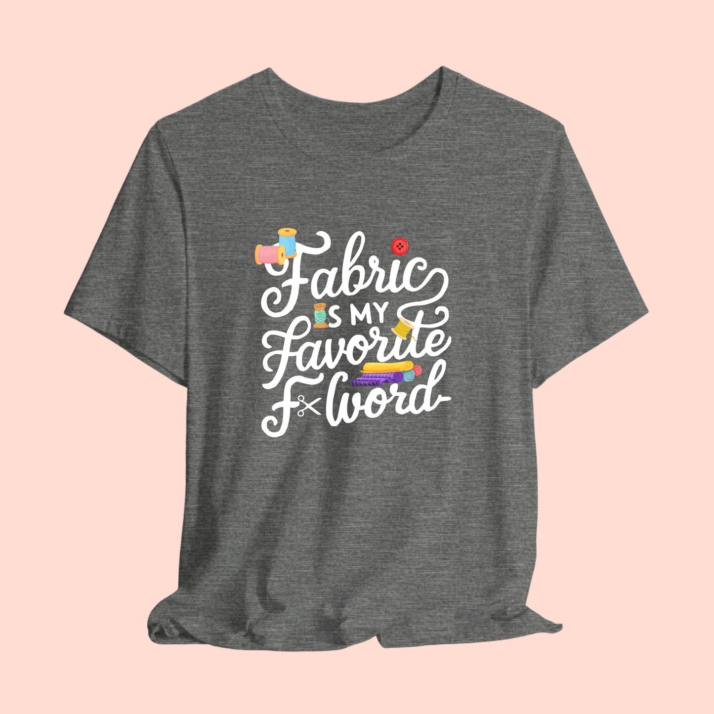 A T-Shirt with the phrase Fabric is My Favorite F-Word in a bold font with thread, buttons, and fabric bolts