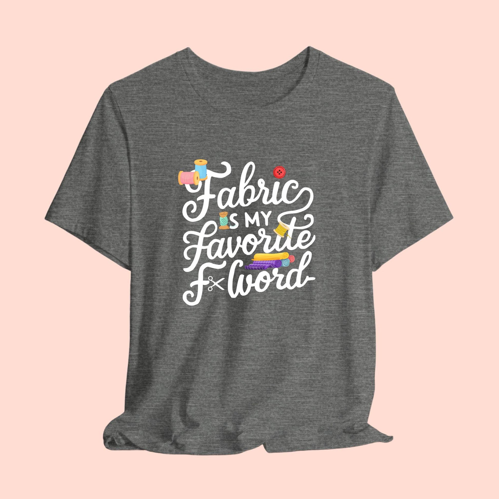 A T-Shirt with the phrase Fabric is My Favorite F-Word in a bold font with thread, buttons, and fabric bolts