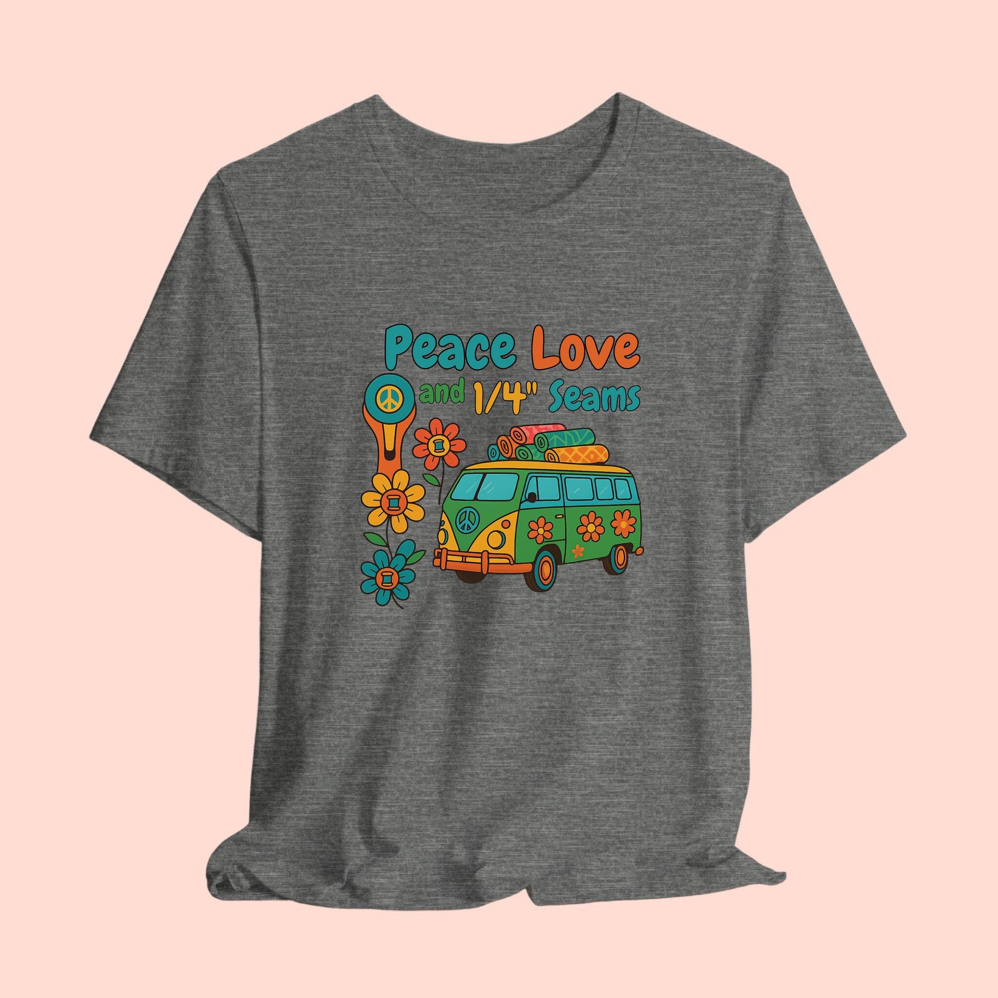 A A t-shirt with colorful retro design showing a peace sign rotary cutter, patchwork van, and text “Peace Love and 1/4" Seams.” Surrounded by flowers made of thread spools. Fun vintage-style quilting shirt.