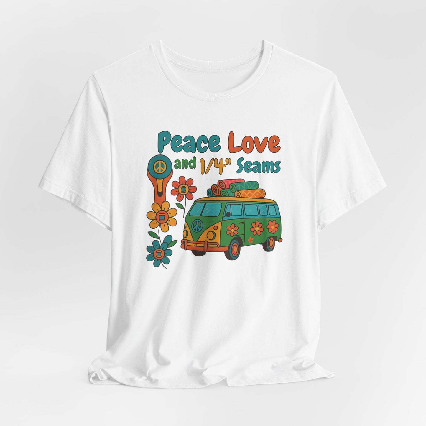 A A White t-shirt with colorful retro design showing a peace sign rotary cutter, patchwork van, and text “Peace Love and 1/4" Seams.” Surrounded by flowers made of thread spools. Fun vintage-style quilting shirt.