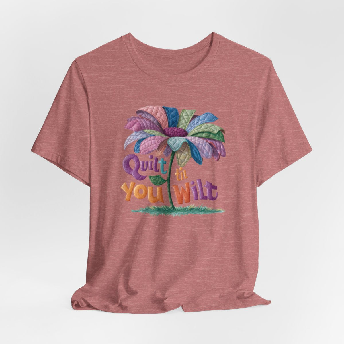 A Heather Mauve funny quilting T-Shirt with the phrase Quilt 'Till You Wilt showing a cheerful, but slightly wilted quilted flower design