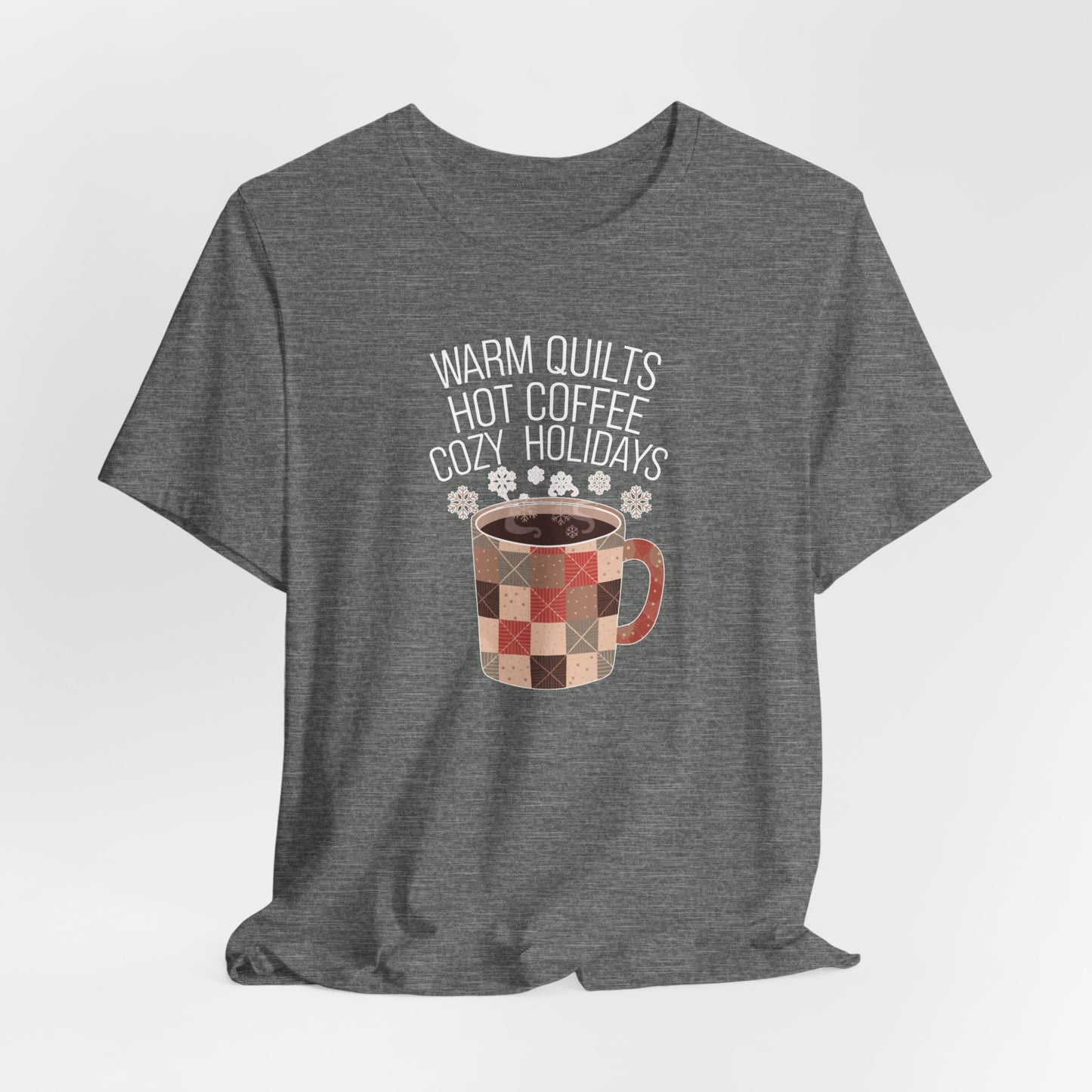 A Deep Heather christmas quilting t-shirt featuring a cozy patchwork quilt-themed coffee mug, surrounded by snowflakes, with the phrase "Warm Quilts, Hot Coffee, Cozy Holidays" above the mug, celebrating the warmth of quilts and coffee during the holiday season.